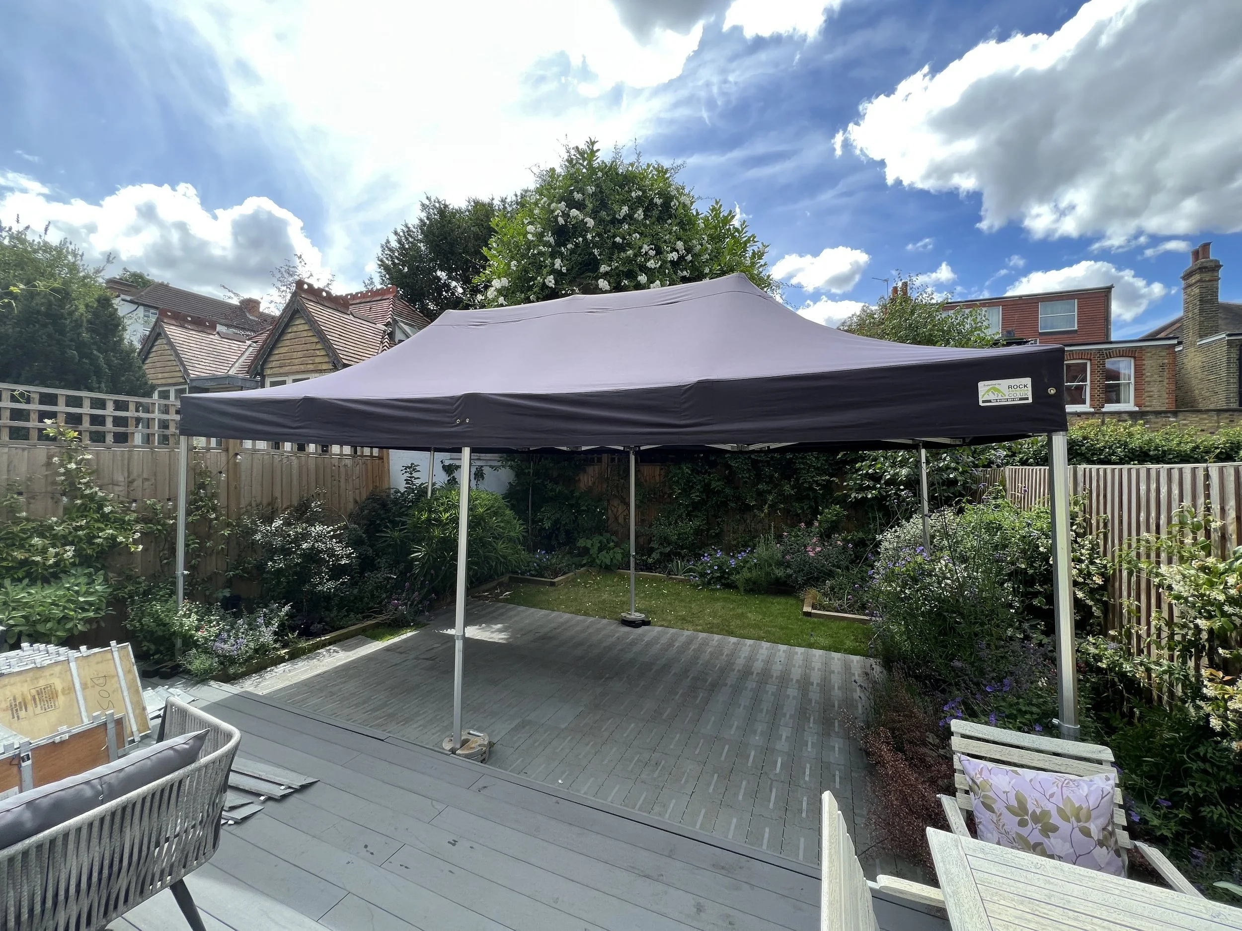 Backyard with a black canopy tent, garden, and outdoor furniture under a partly cloudy sky. marquee hire
gazebo hire
party tent hire
party marquee hire
event tent hire
wedding marquee hire
pop up gazebo hire
corporate event tent hire