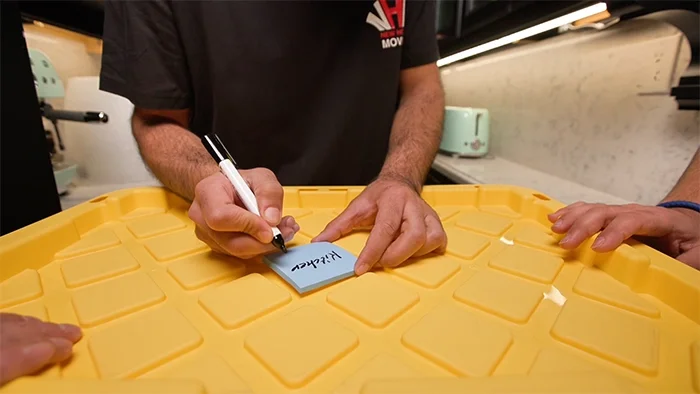 Professional movers labeling storage bins for organized internal moves and in-home relocation services in Toronto.