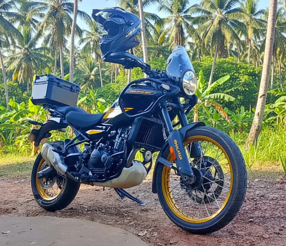 Black and gold Royal Enfield Himalayan 450 in Cambodia with a jungle background