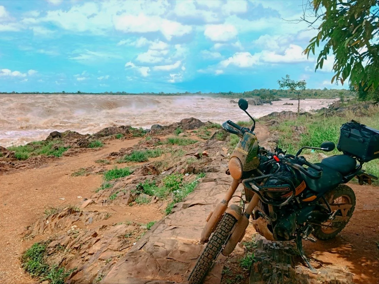 Royal Enfield Himalayan 450 motorbike on a dirt road by the Mekong shore and nature with a blue sky