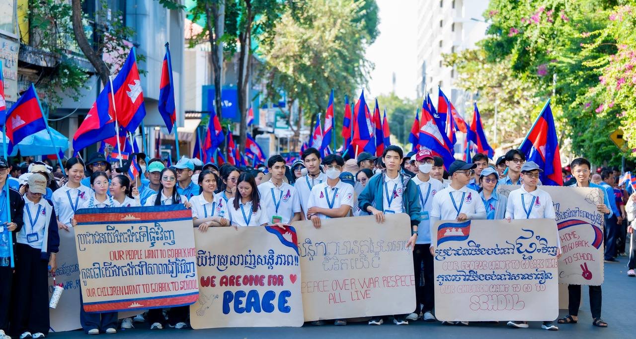 Young Cambodians wearing white clothes with flags and board signs for a walk peace in Phnom Penh