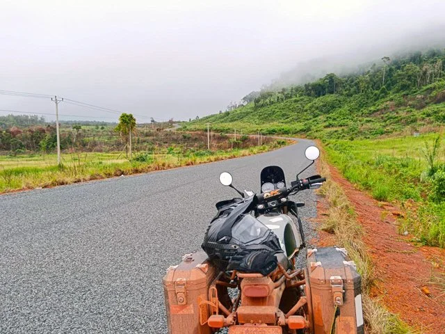 Adventure motorbike on a new paved road winding through the Cambodian mountains
