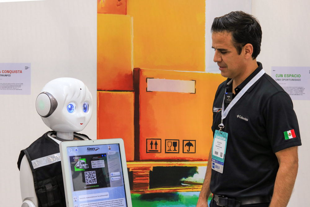 Un robot conversando con un hombre en un entorno de exhibición, con un fondo de pintura abstracta en tonos cálidos.