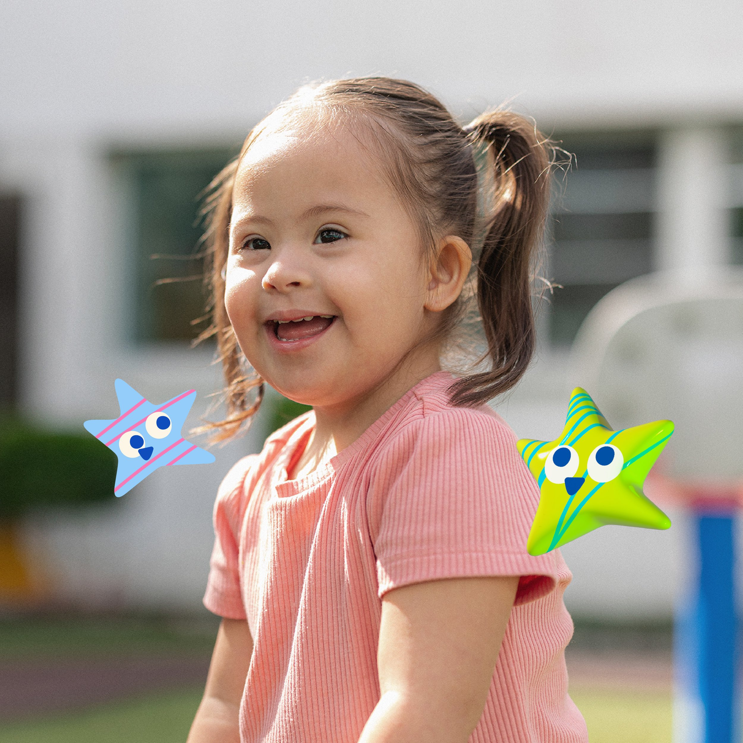 A young girl with brown hair tied in a ponytail smiling outdoors, wearing a pink shirt, with colorful cartoon star illustrations around her. Tedi vanguardia en sindrome de down