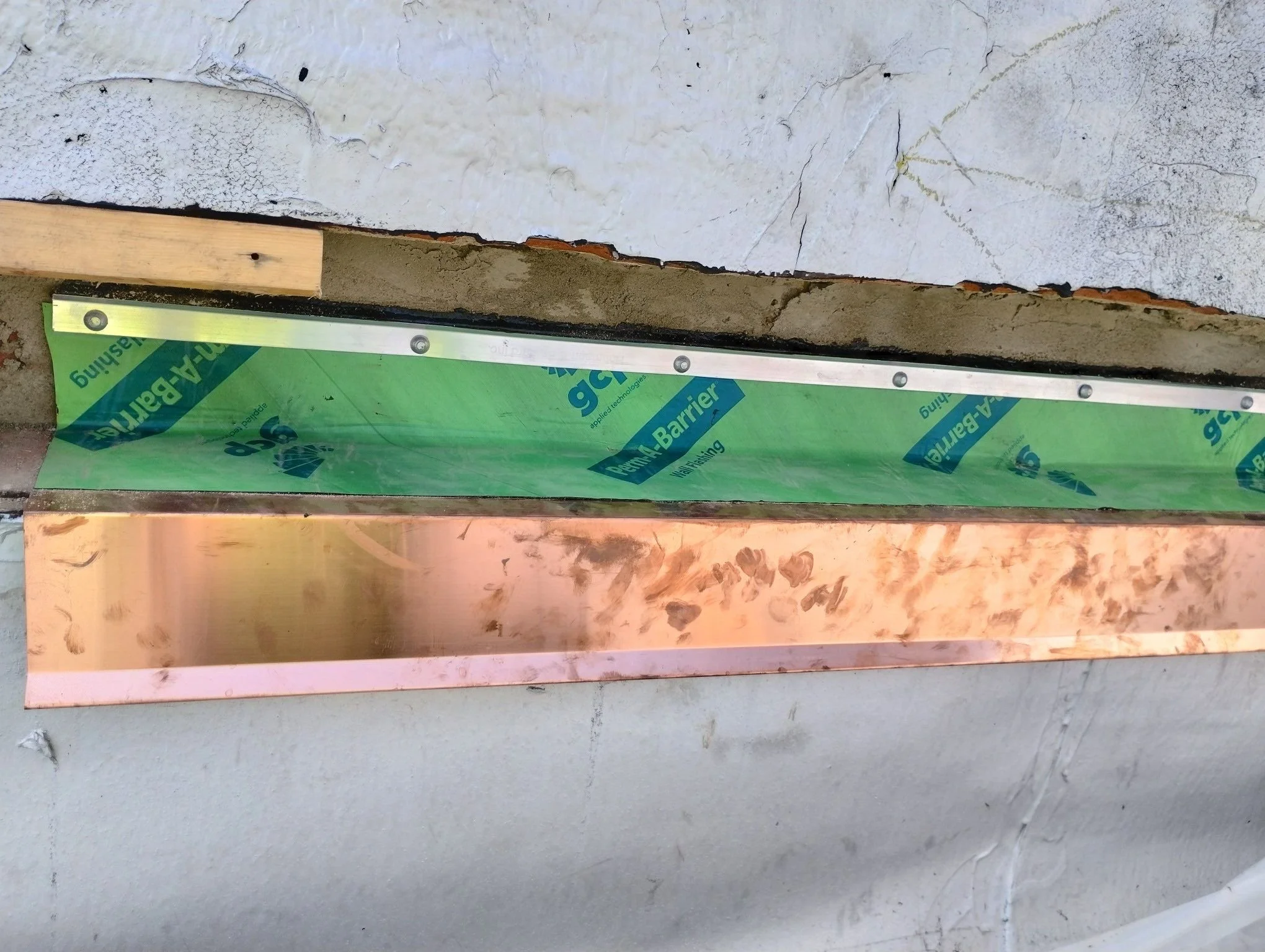 Close-up of a new copper through-wall flashing detail with new GCP perm-a-barrier waterproofing. 