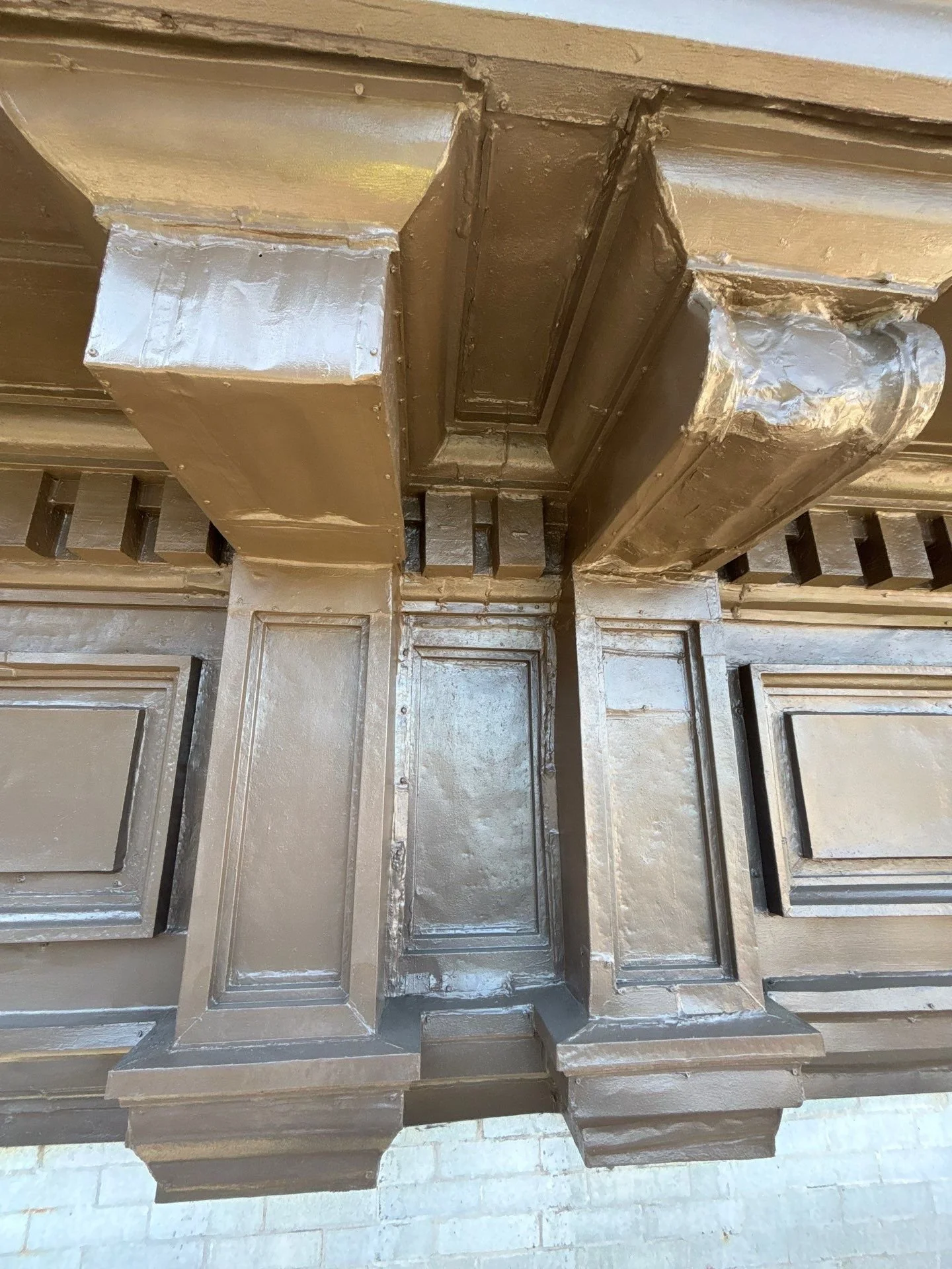 Cornice repair on historical NBC architectural cornice with detailed molding, attached to a brick wall.