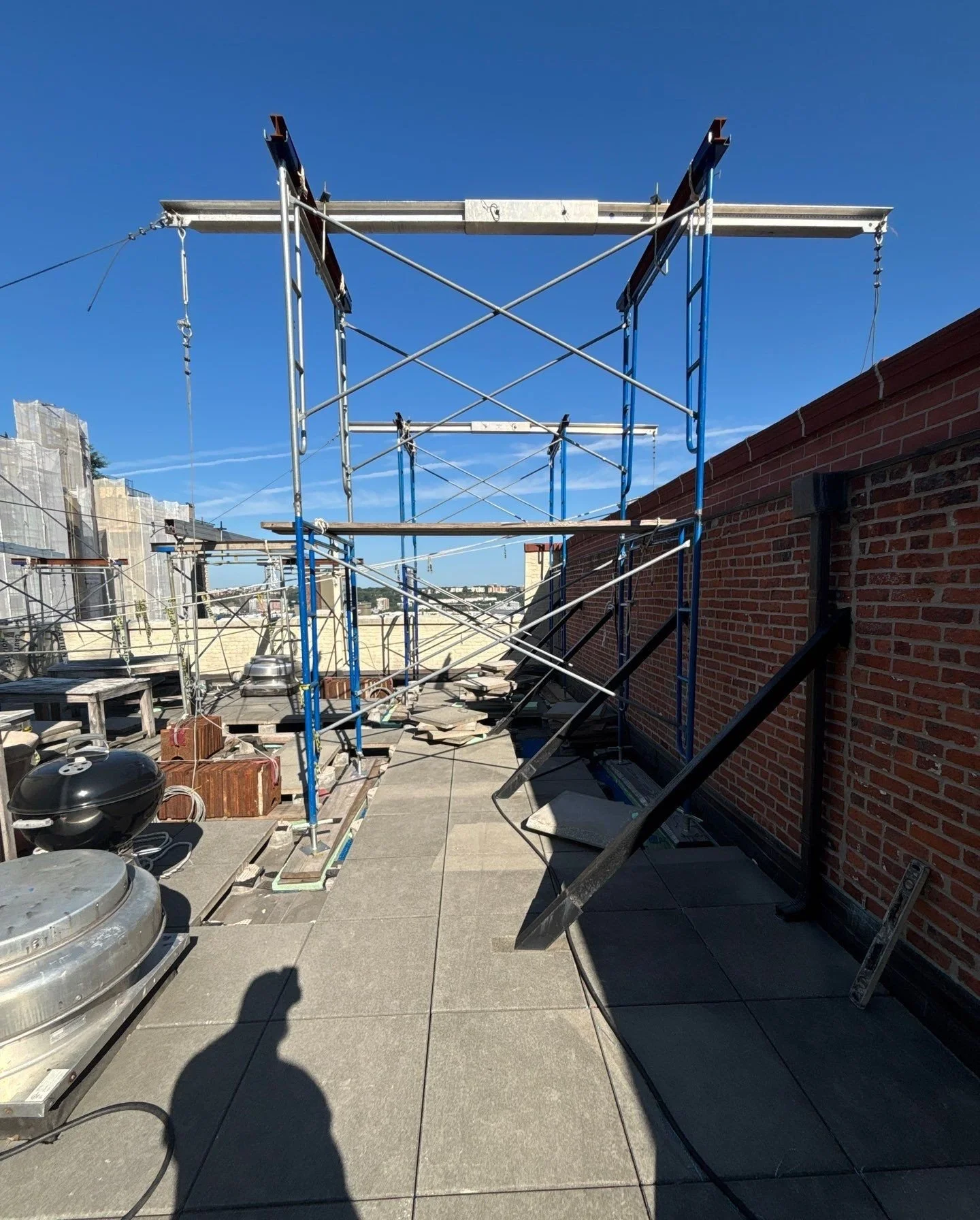 Scaffolding on the rooftop of a building with a blue sky background.