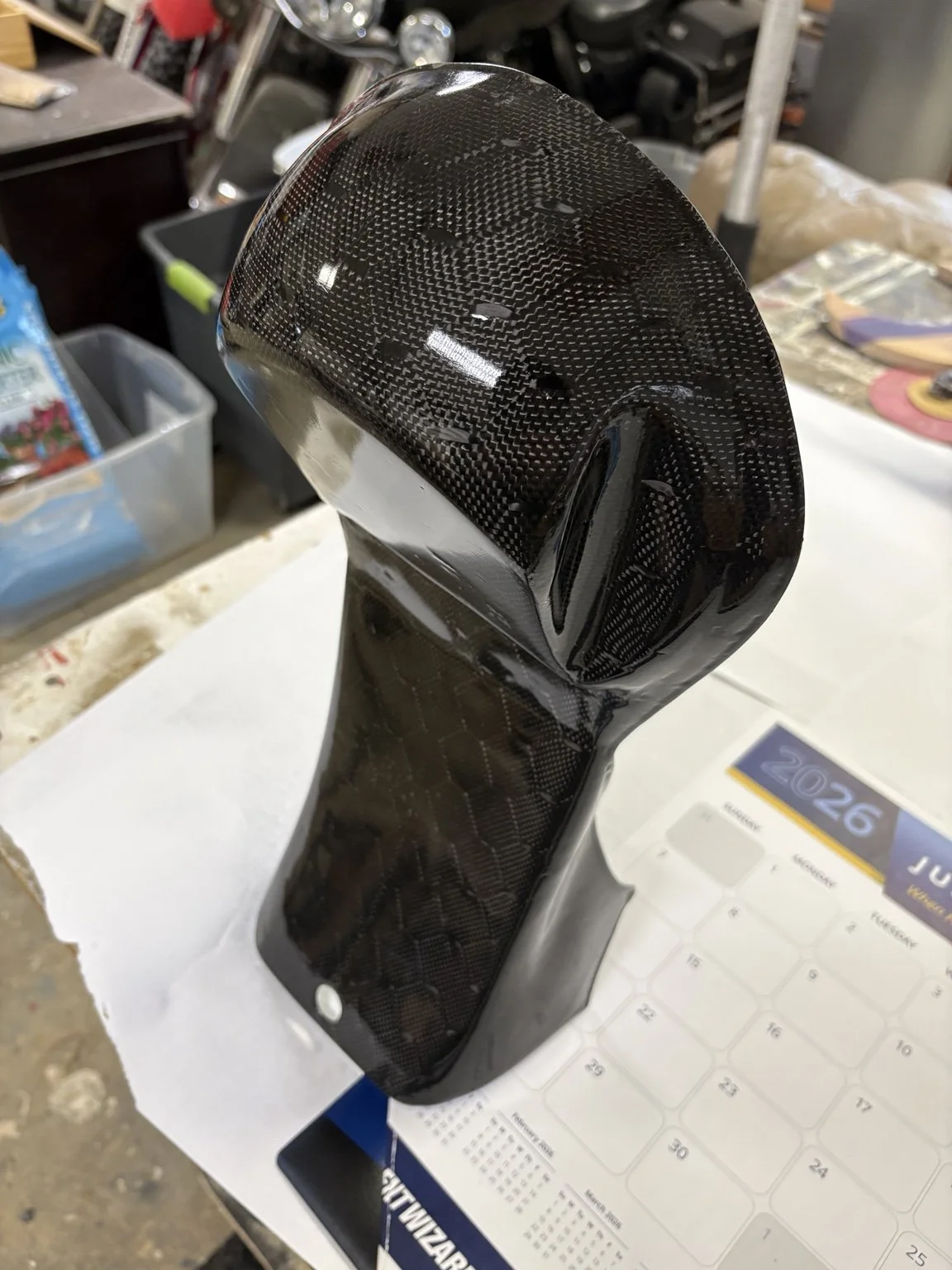 Carbon fiber seat cowl produced from the finalized mold, demonstrating surface finish, structural integrity, and readiness for final installation.