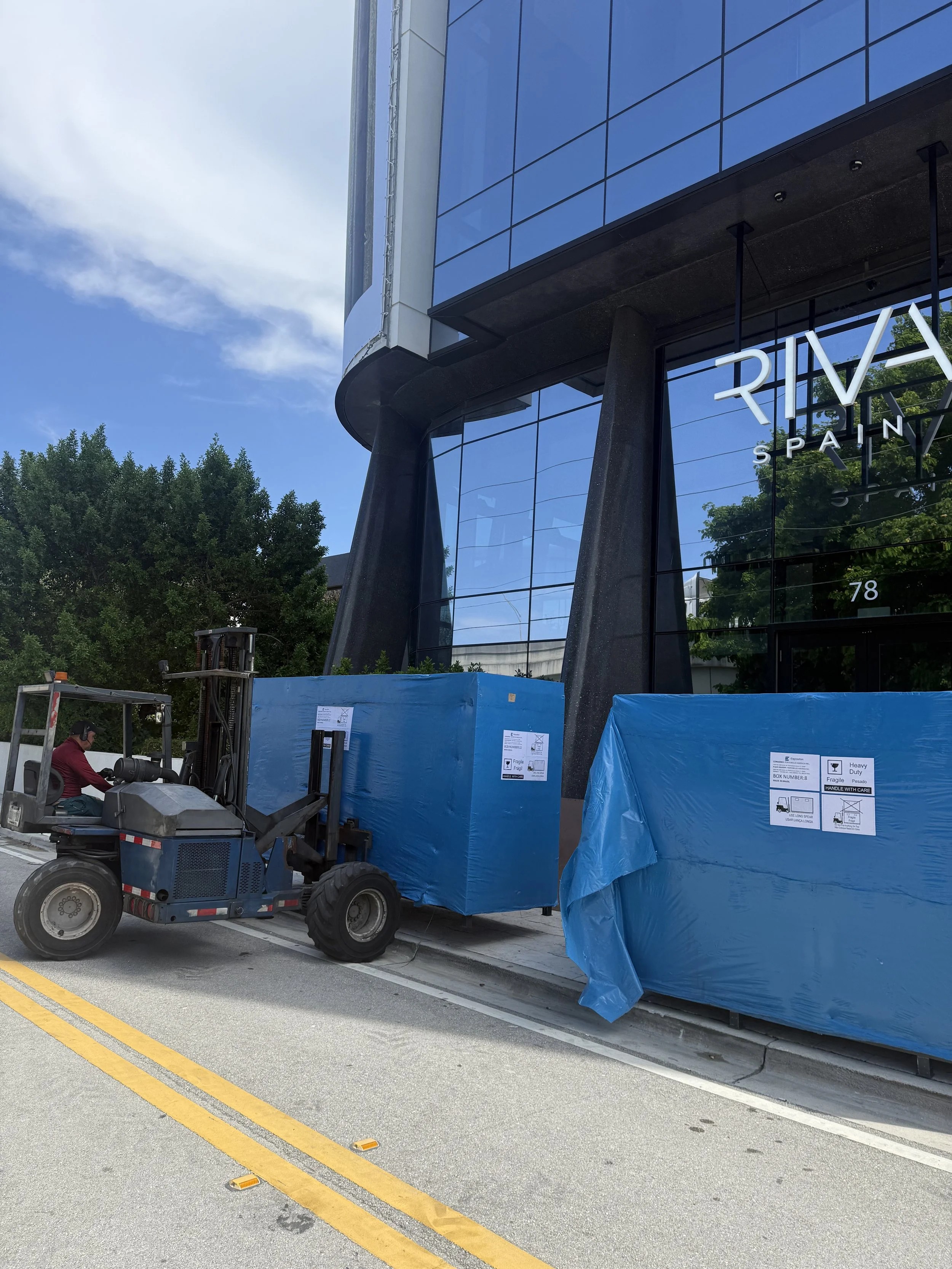 Commercial movers unloading oversized tile pallets outside Wynwood showroom during multi-day Miami commercial relocation