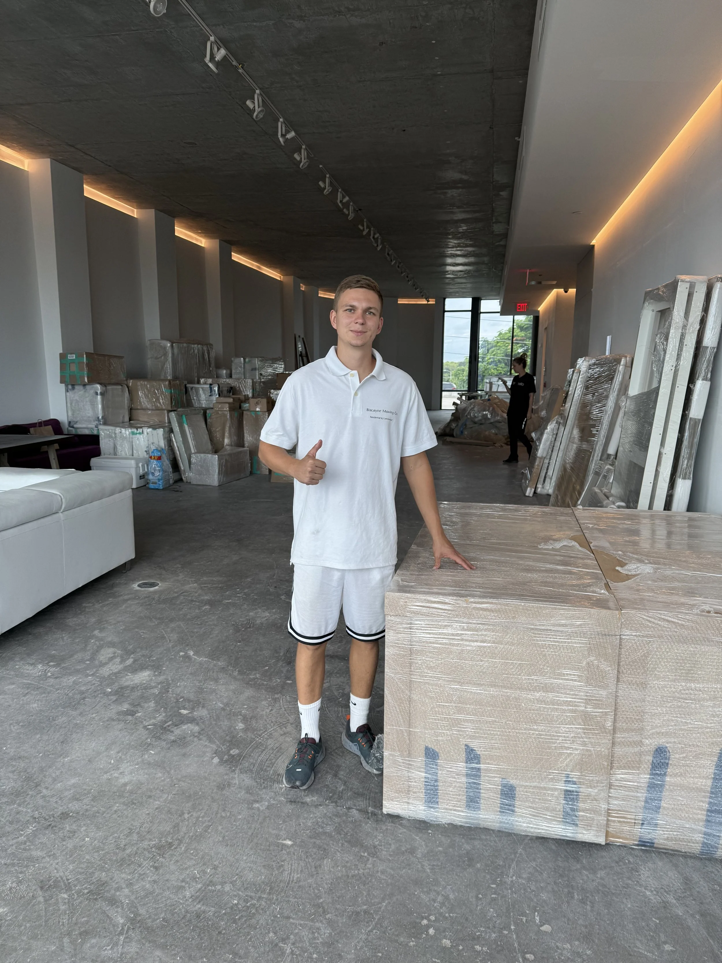 Biscayne Moving Co. worker smiling on-site during a large commercial moving job in Wynwood, Miami—professional South Florida movers handling business relocations with white-glove service