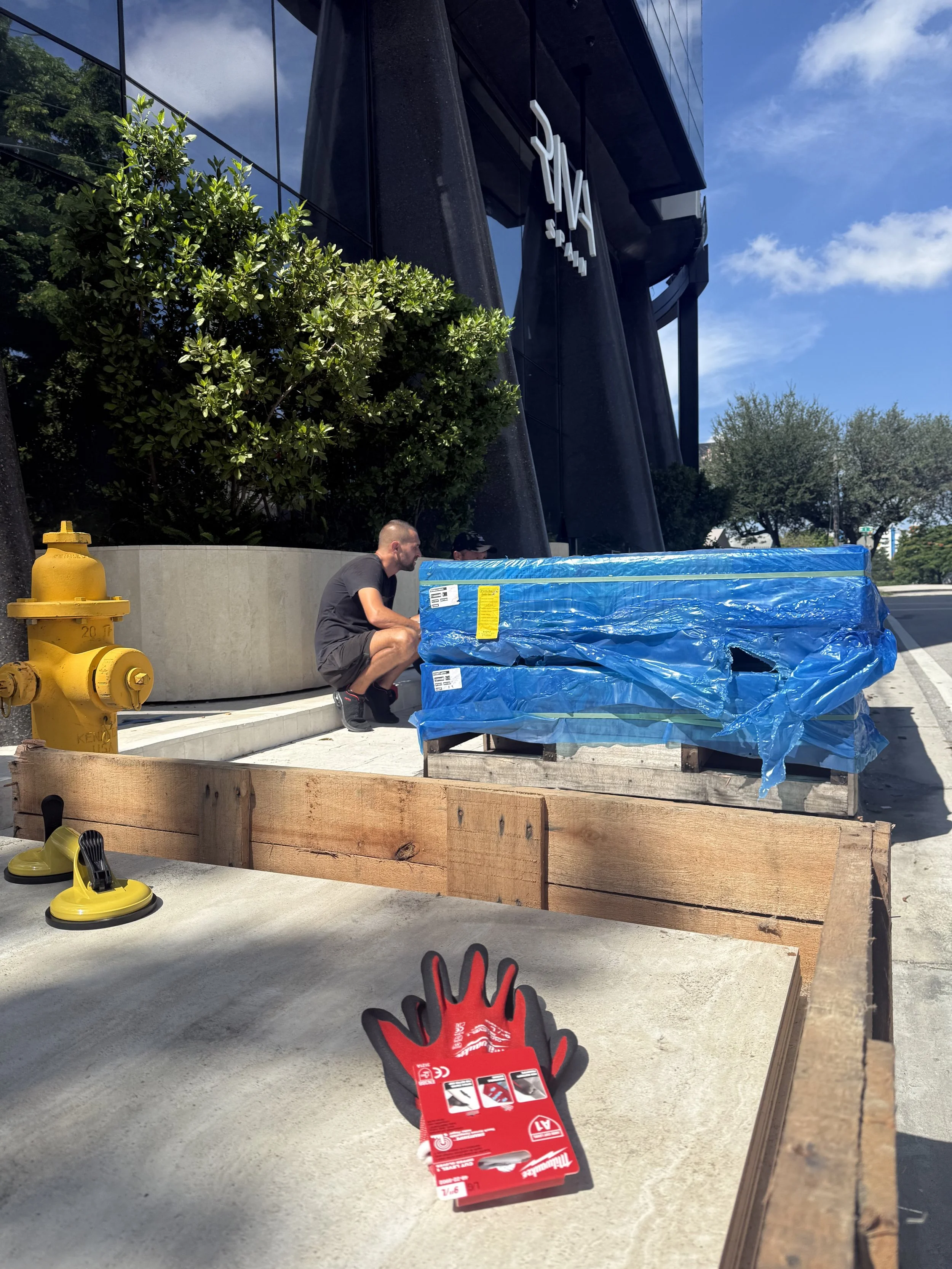 Professional commercial movers uncrating ceramic tile for showroom installation during Wynwood commercial move
