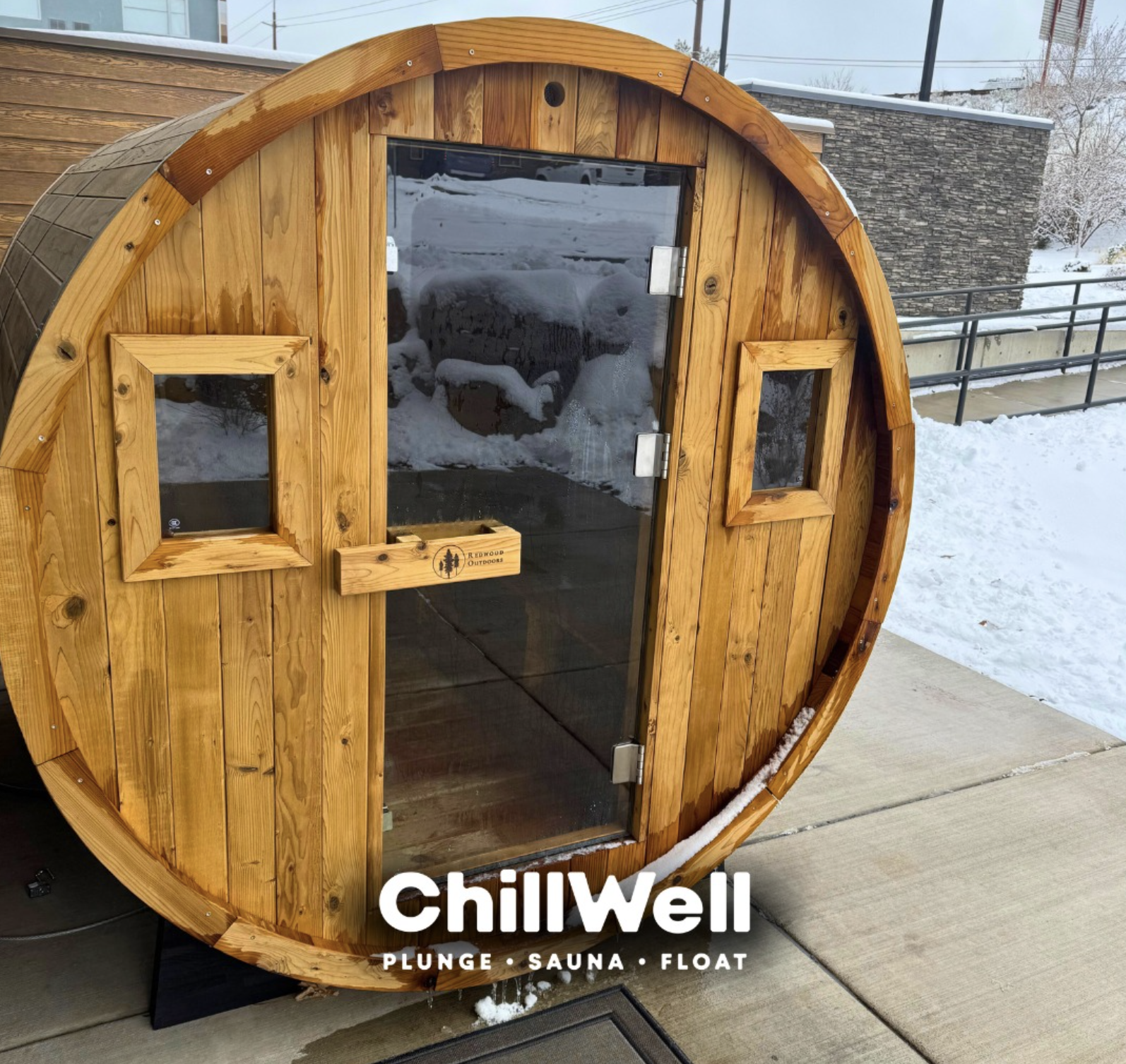 The exterior of a ChillWell store with a sign displaying services like plunge, sauna, and float, surrounded by autumn trees and a blue sky.