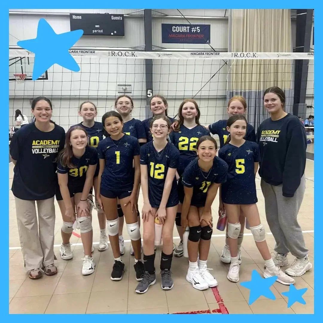 TCP Travel Academy Volleyball team of middle school girls and coaches posing proudly on an indoor court at The R.O.C.K. in Western New York, wearing matching navy and yellow uniforms after a tournament game