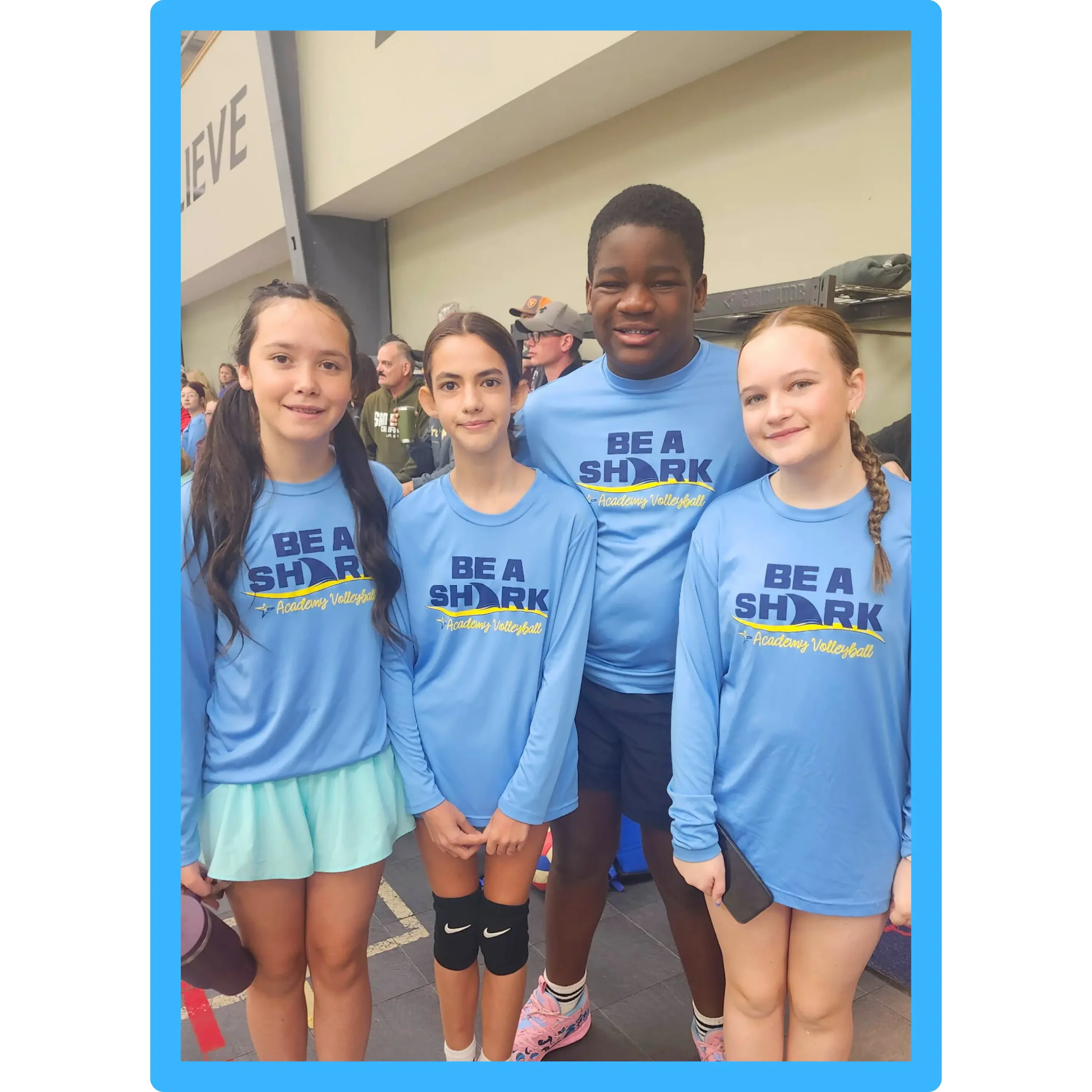 roup of youth athletes in ‘Be A Shark’ shirts from TCP Academy pose together at an indoor volleyball event, promoting inclusion, teamwork, and skill development