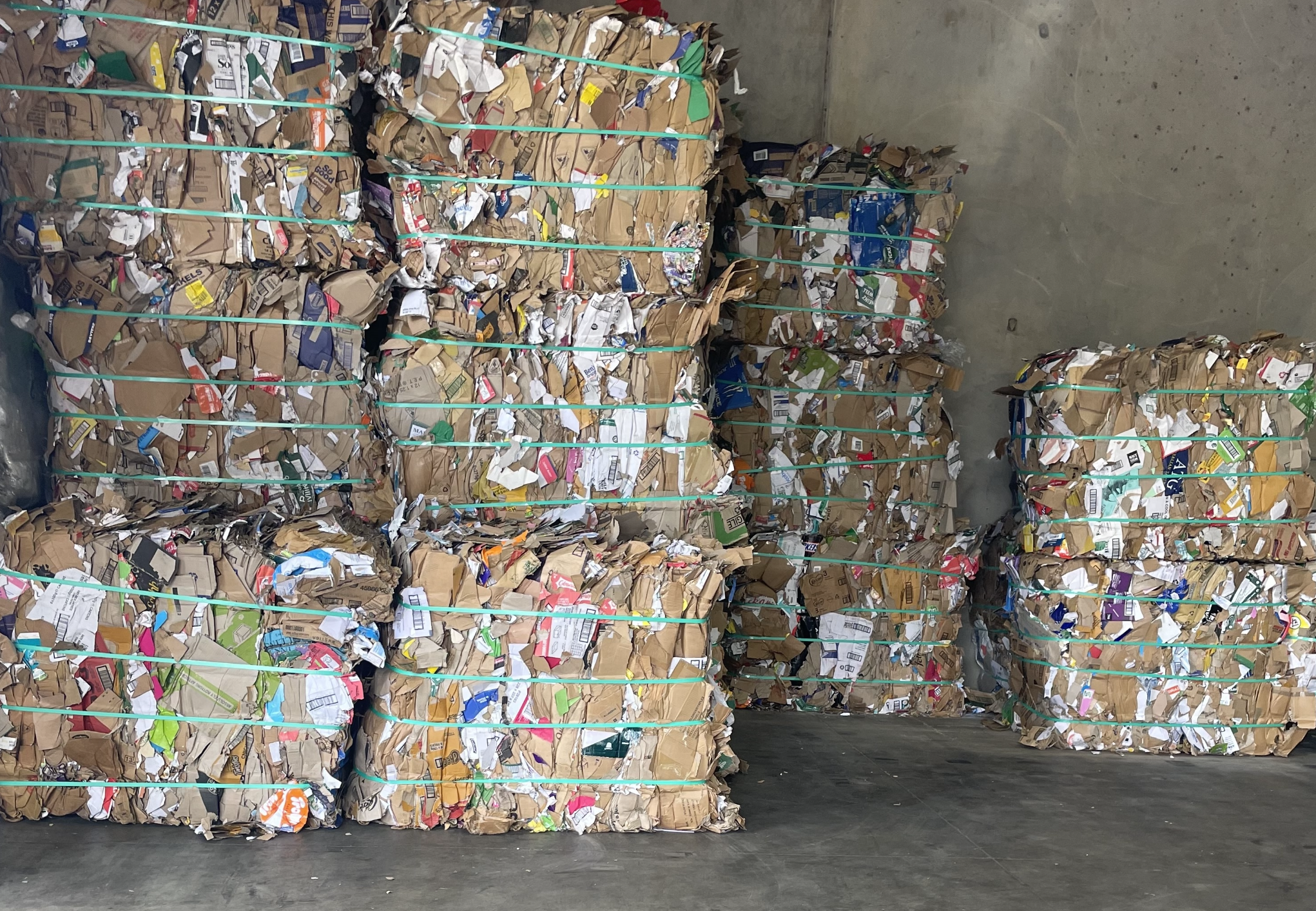 Stacks of compressed shredded paper and cardboard waiting for recycling.