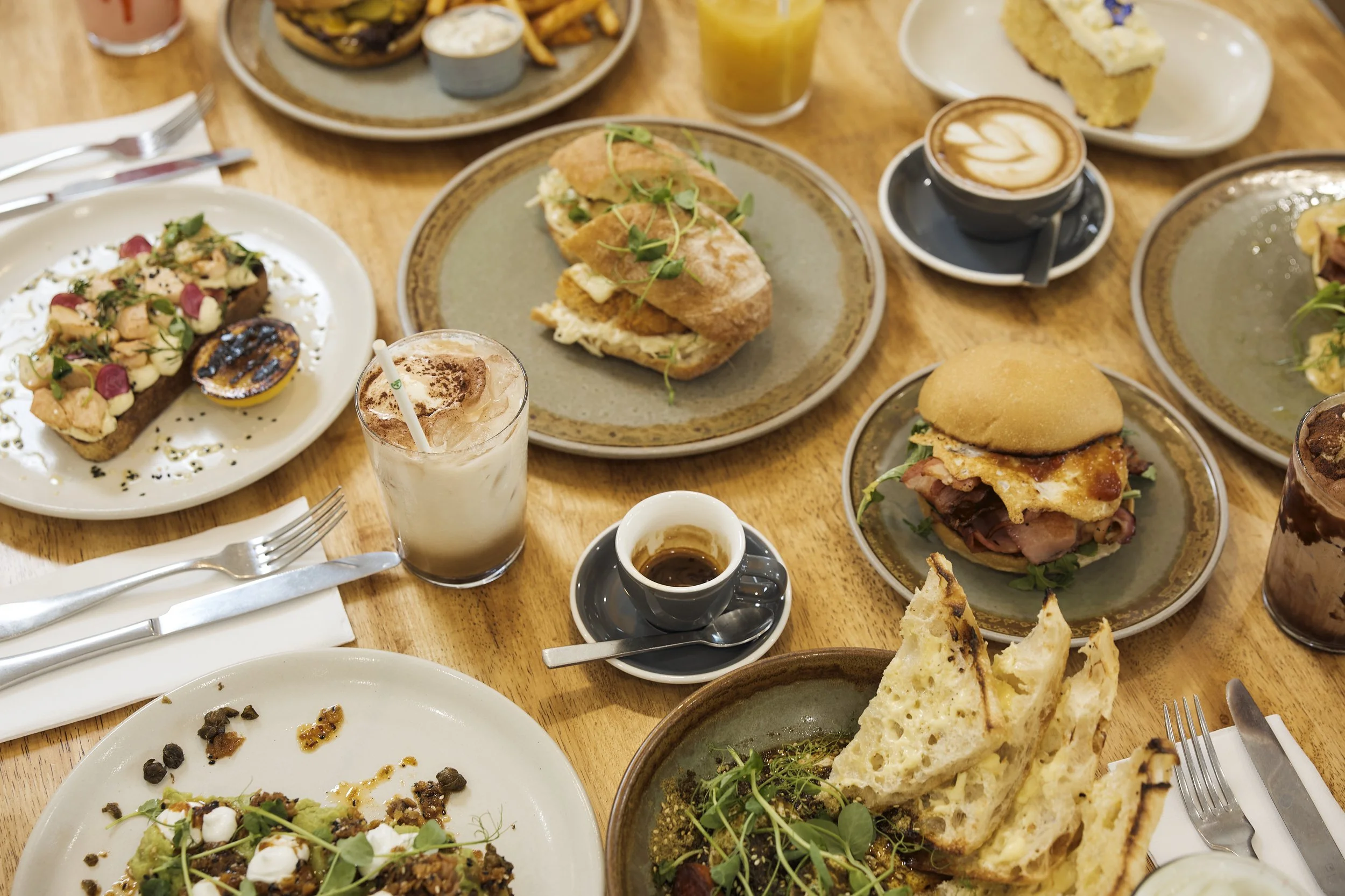 Brunch spread with sandwiches, coffee, and pastries at Dose Hospitality George Oyster Bay café in Sydney