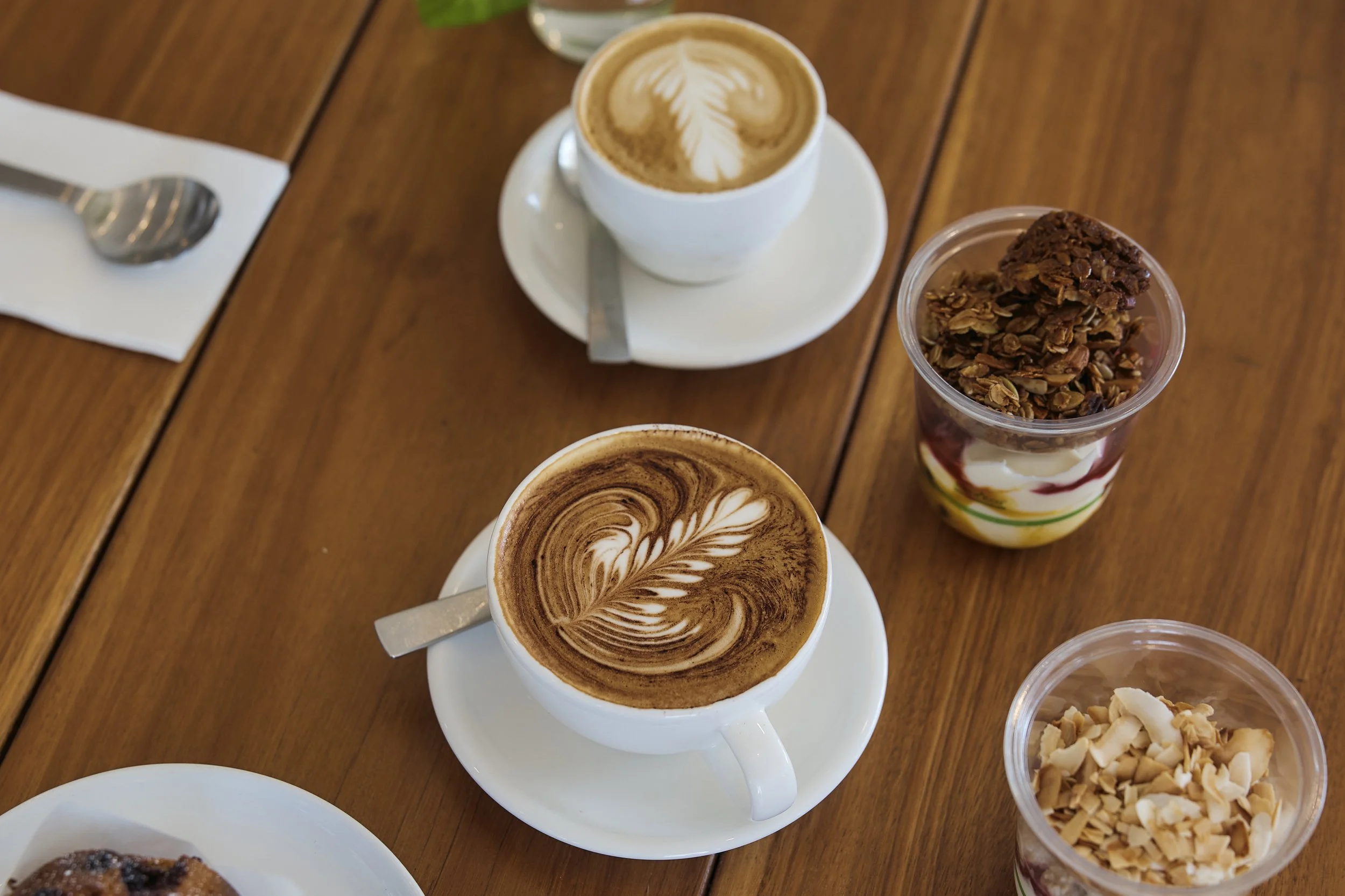 Flat white served on a wooden café table at Dose Hospitality in Sydney
