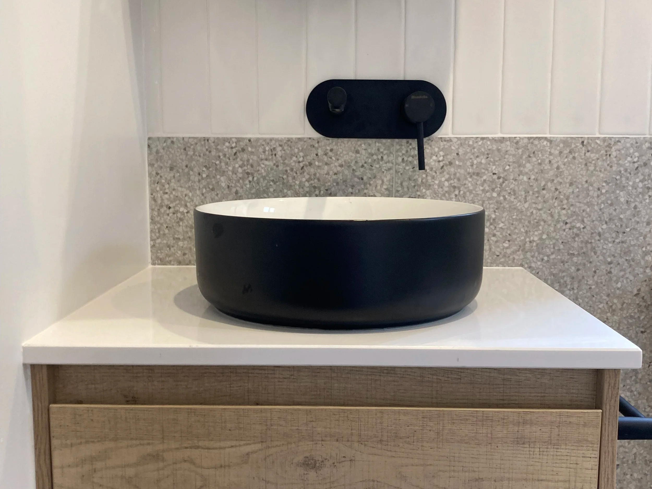 view of the black exterior, white inside basin in the modern, refreshed bathroom 