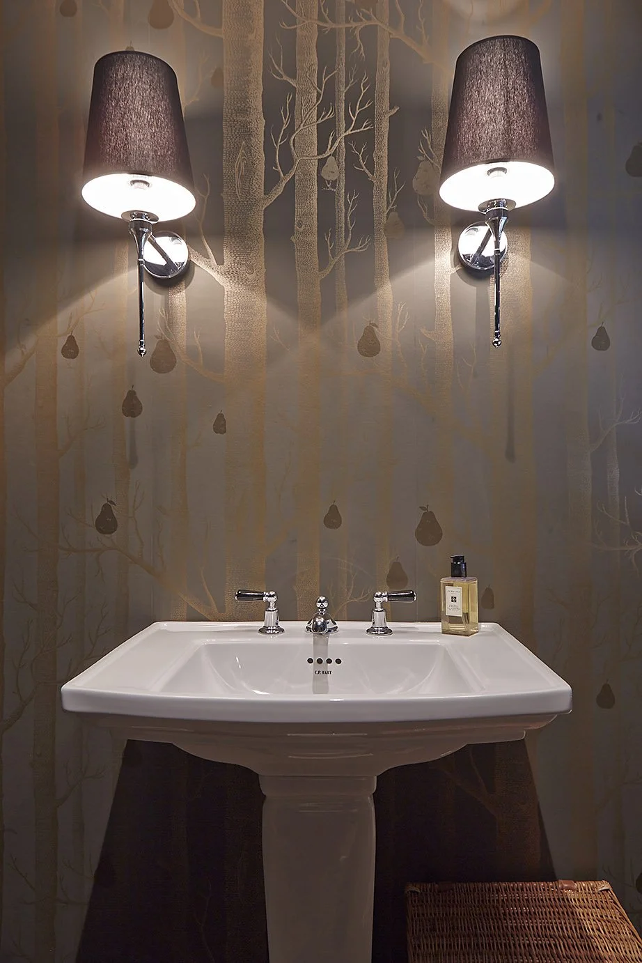 bathroom sink in art deco home, against pear and tree trunk wallpaper