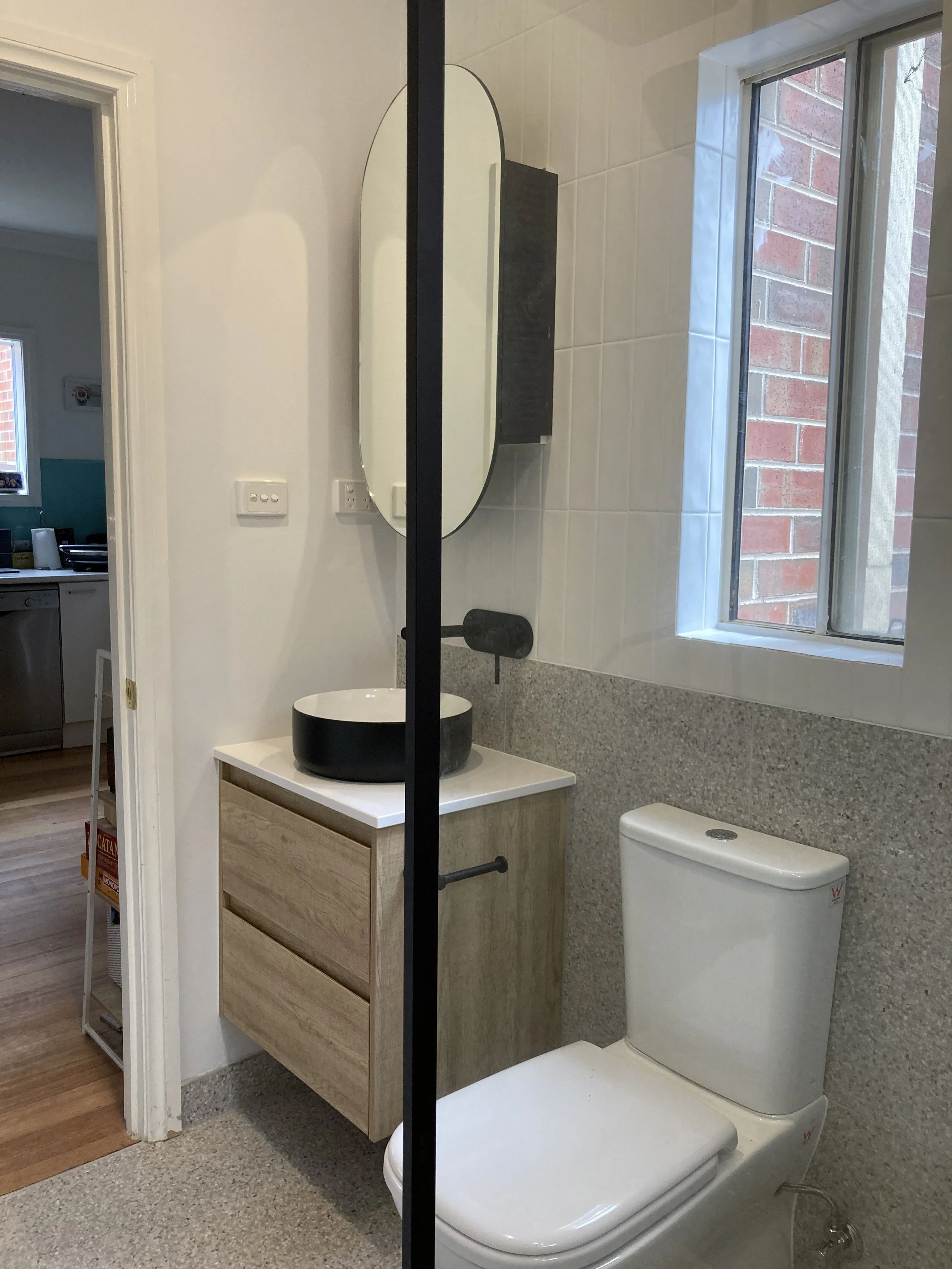 View from shower, we see the toilet and vanity.