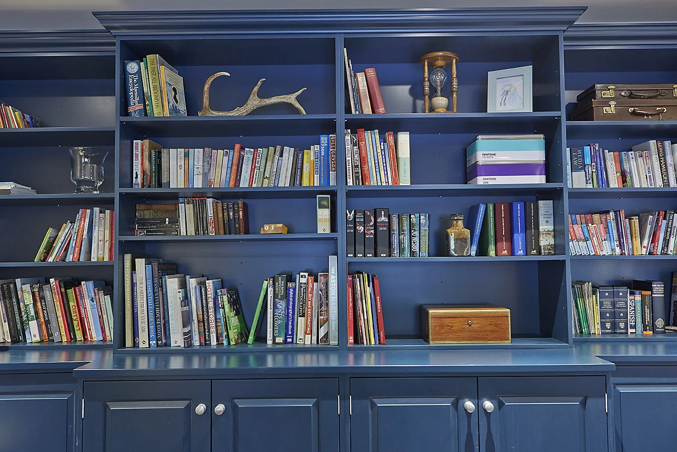 wide view of blue bookshelf, loaded with books and decorations 