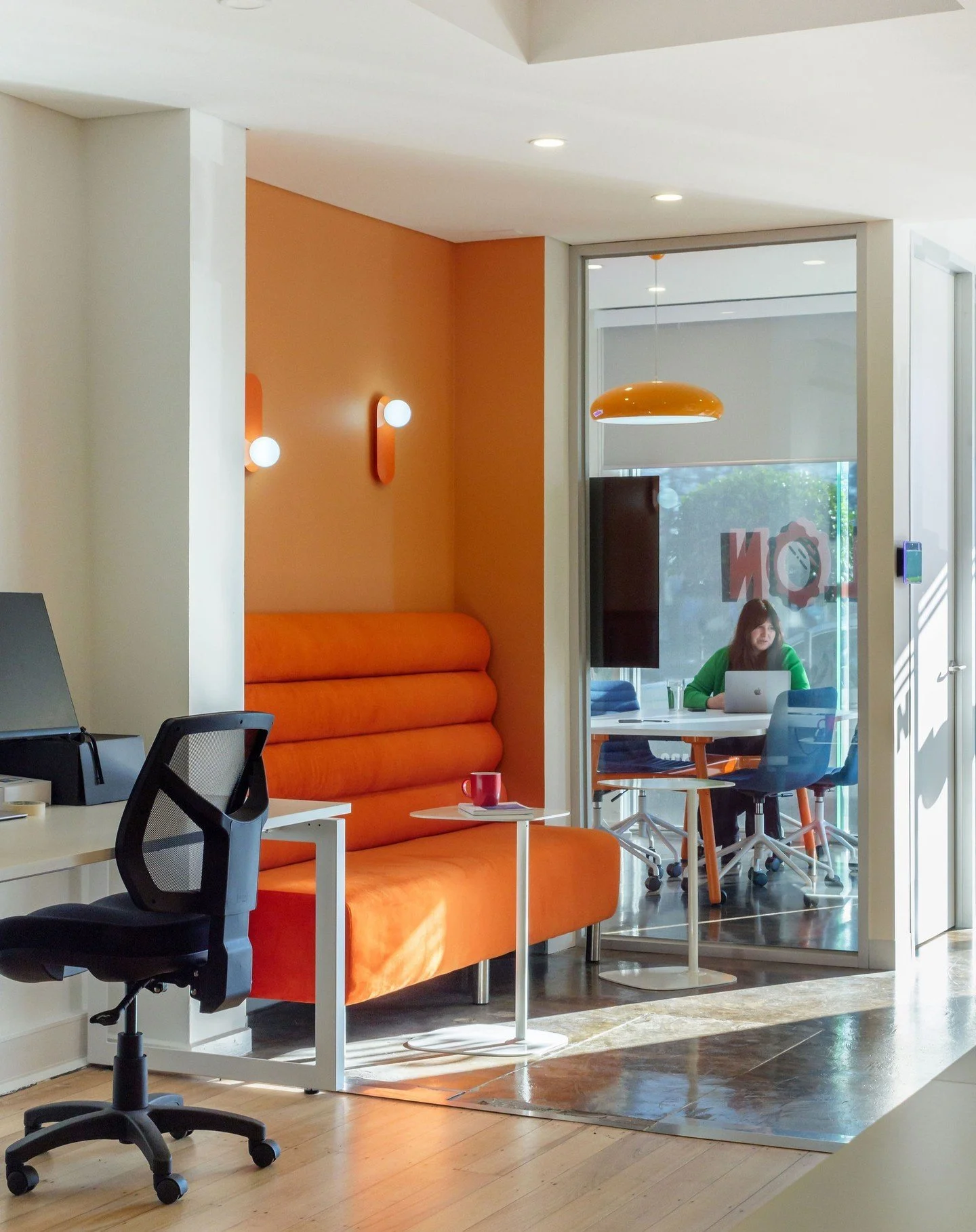 Wide view of office interior design, showing desks and sitting area, modern commercial interior design