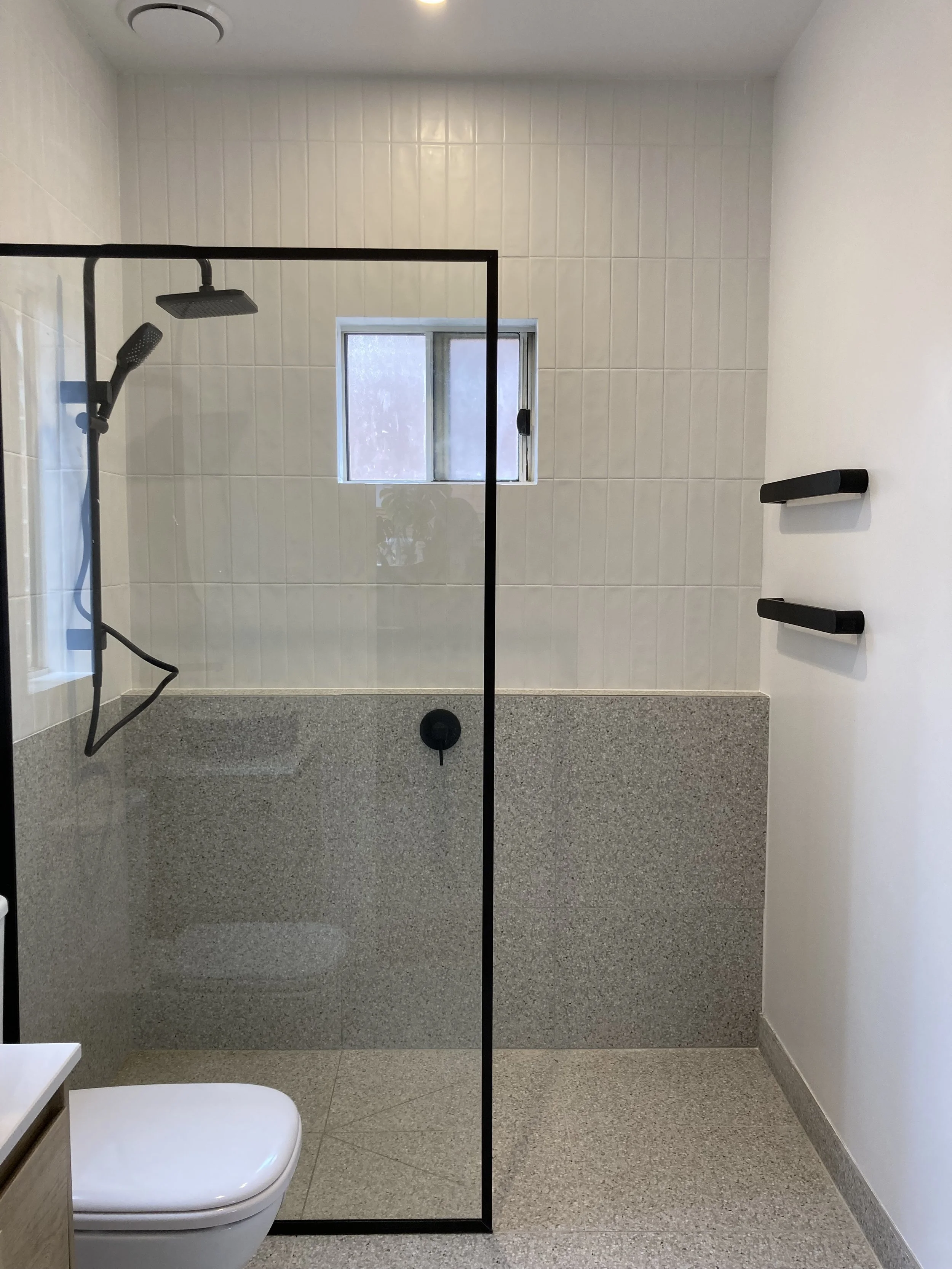 side view of the shower with black accents and open door design.