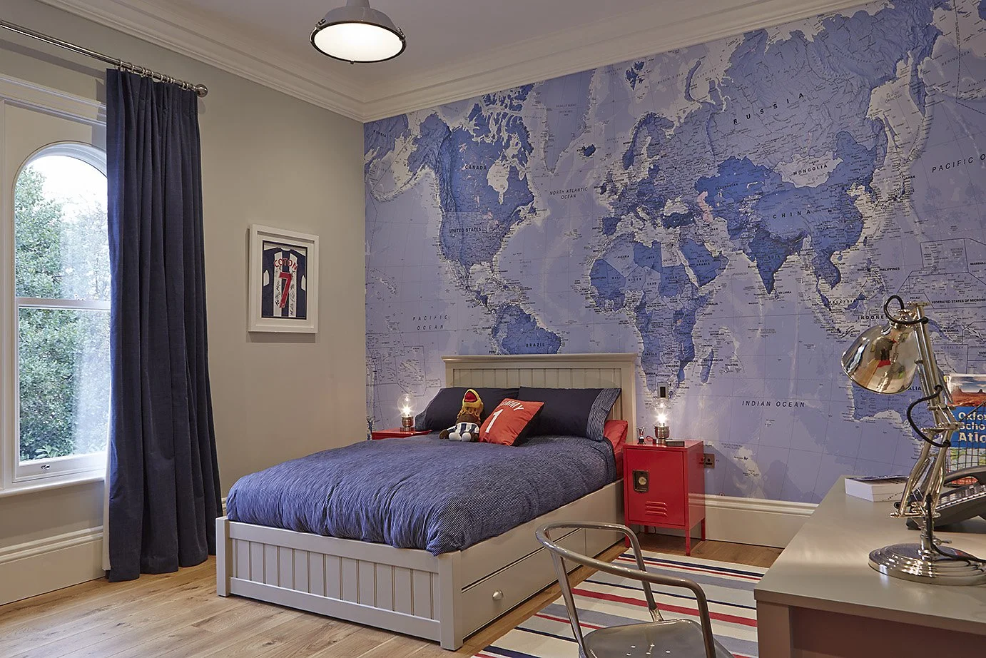 Bedroom with blue decorations and world map on the wall.