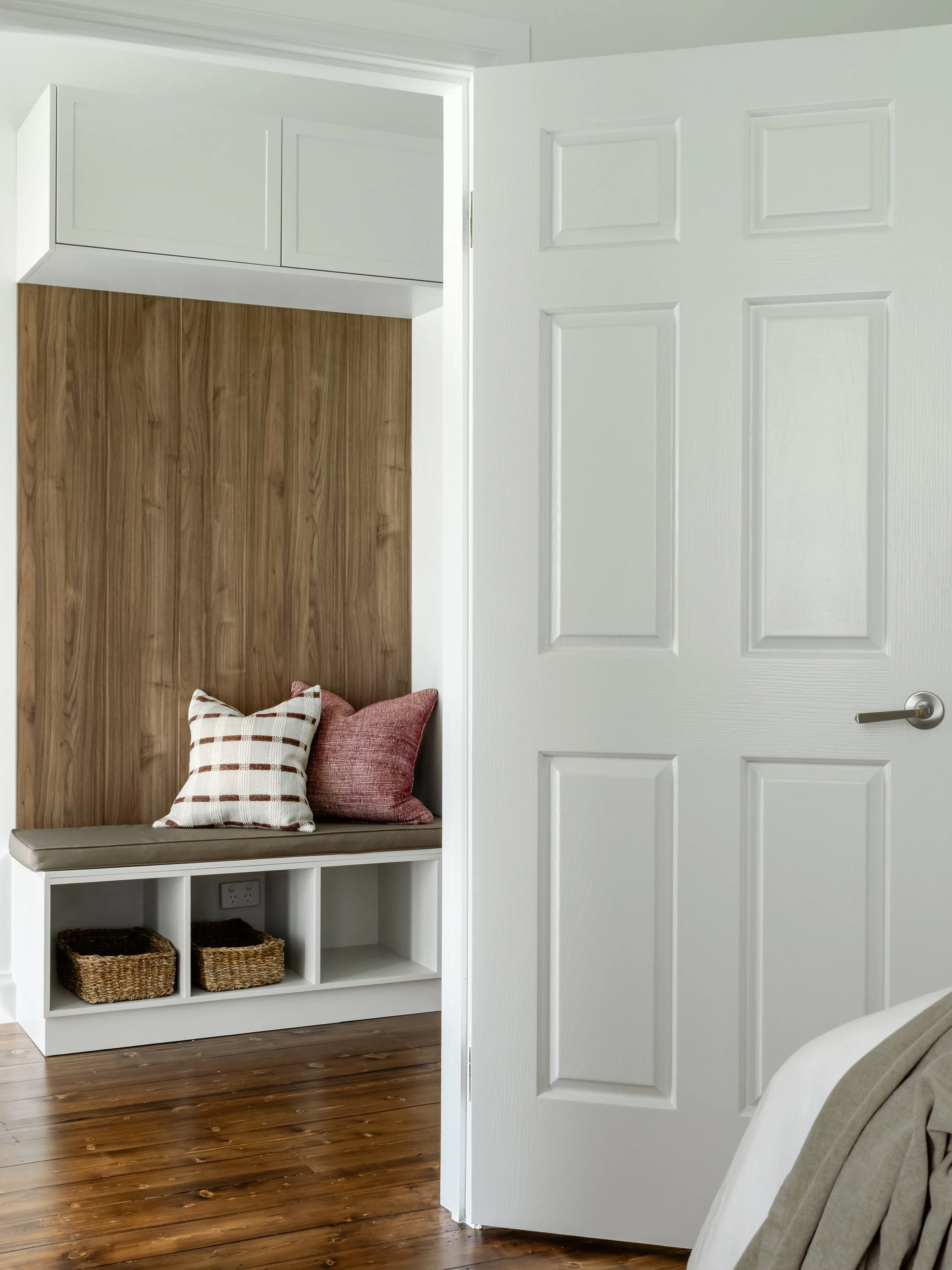 view from room showing hallway bench with cushions, neutral earthy colours 