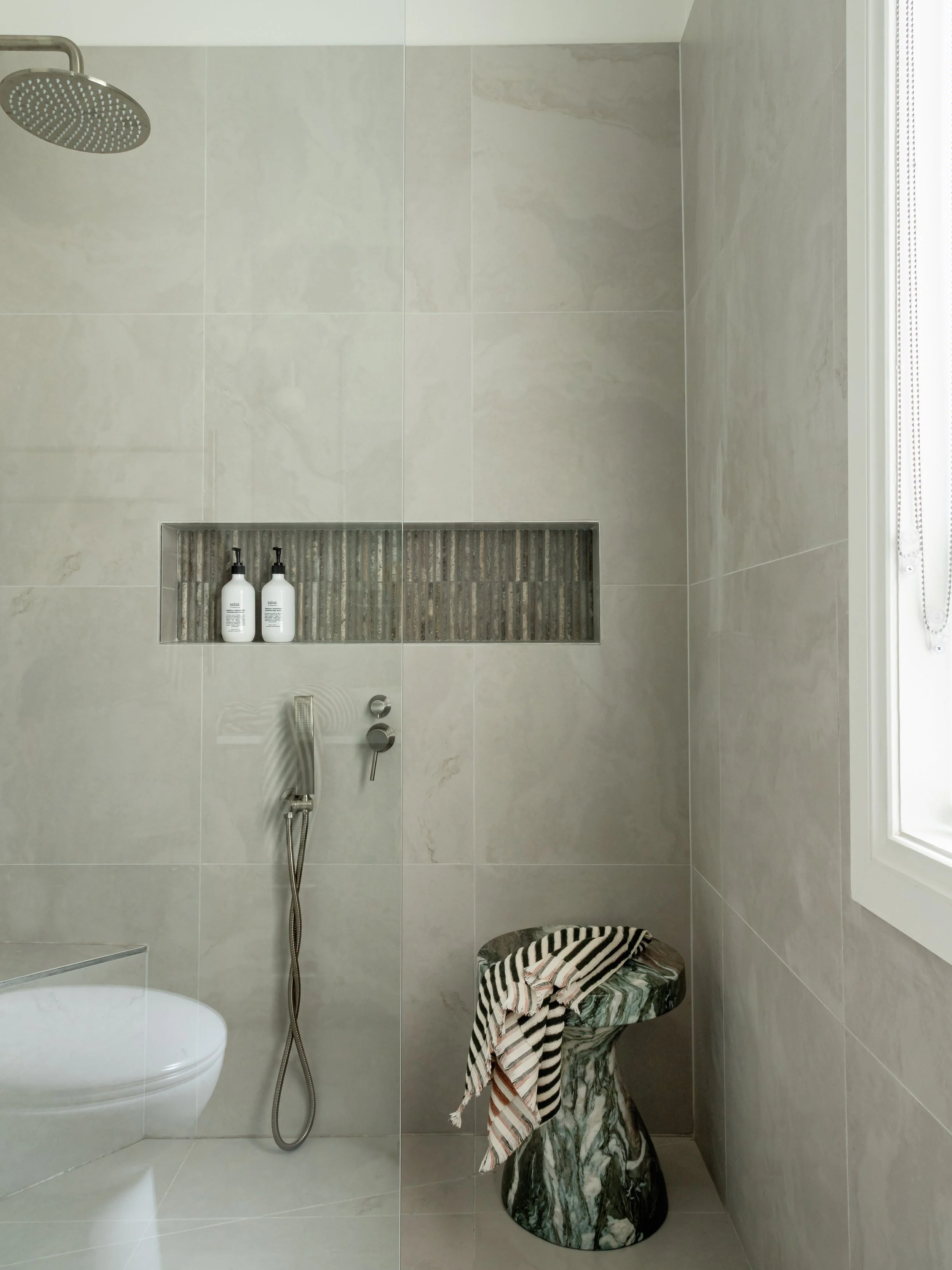 shower with inset shelf, stone table, toilet, earthy feel
