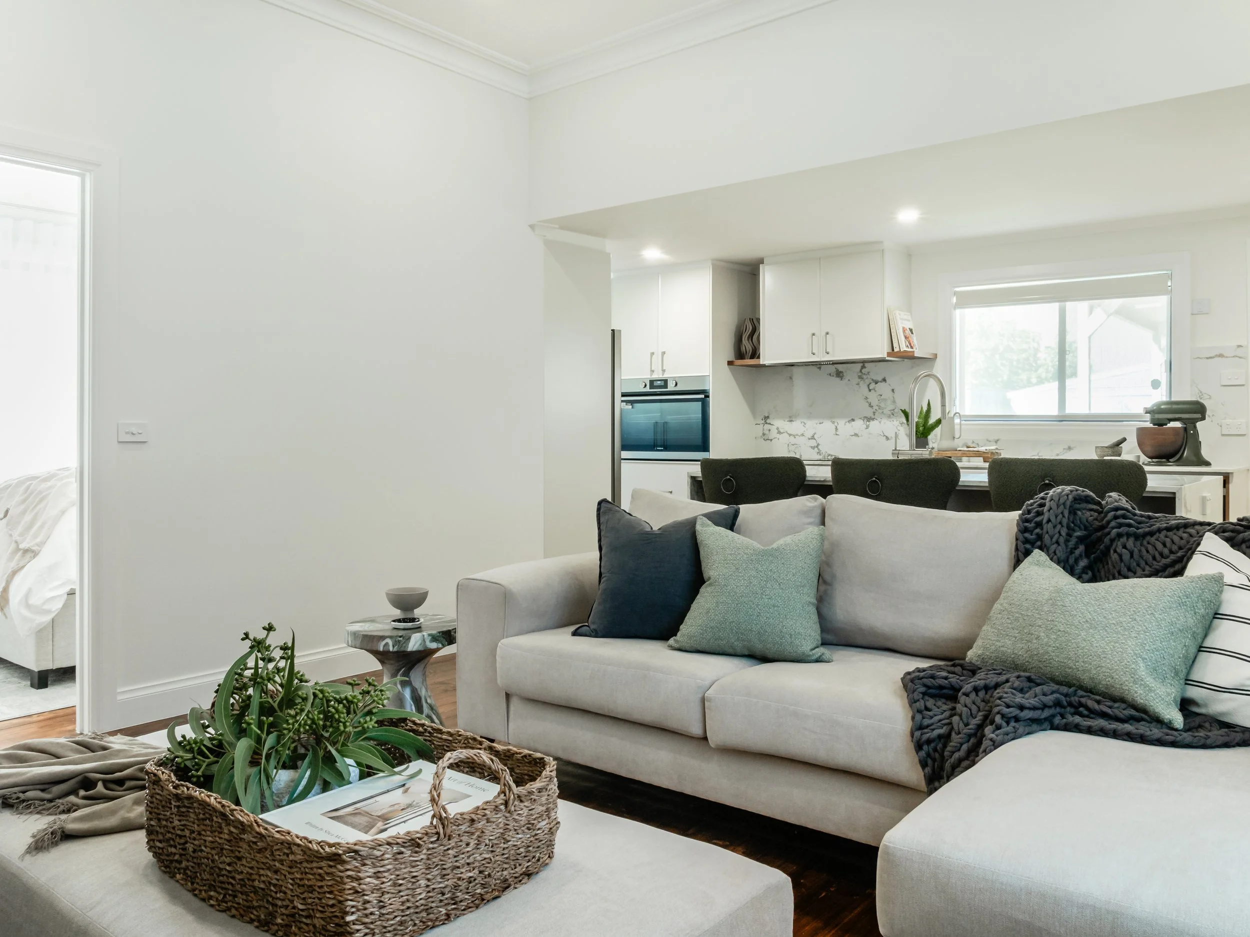 Neutral, minimal, calm interior. Wide view of living area and kitchen 
