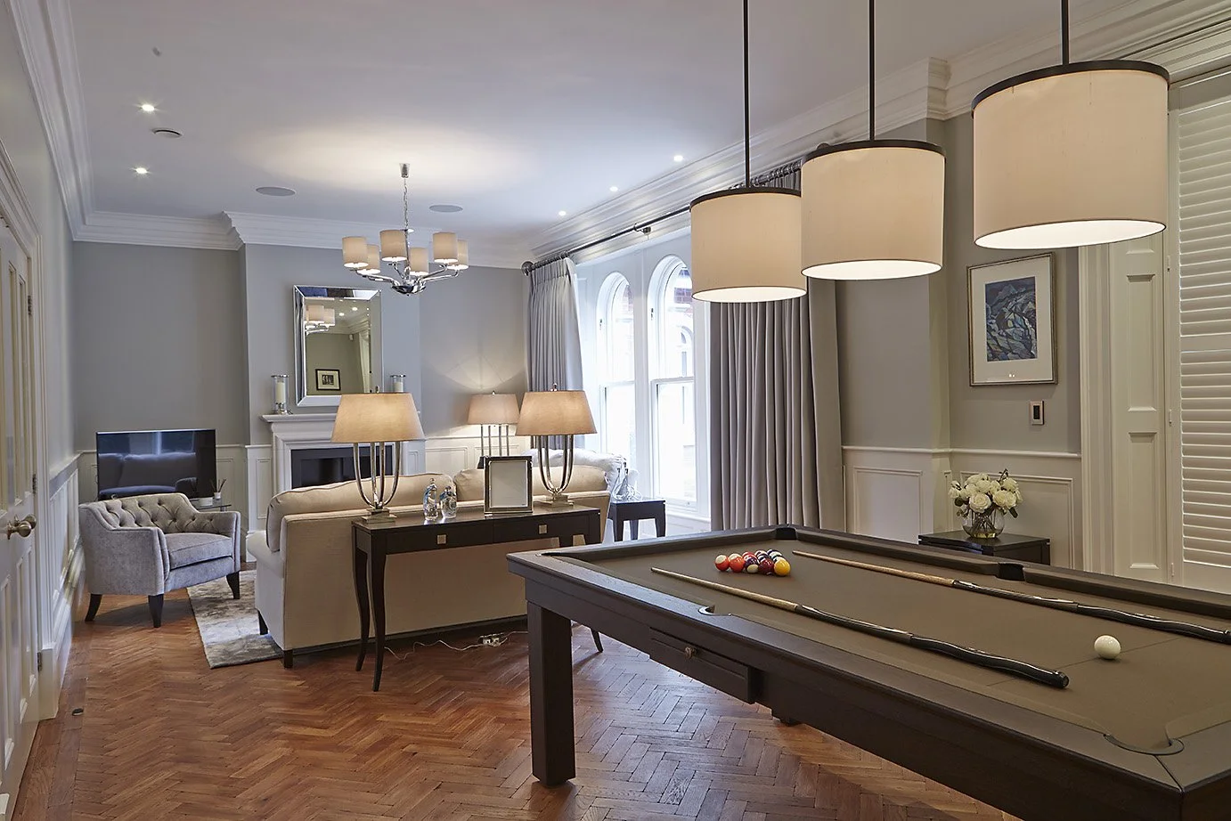 Living and recreation space in a Victorian Style home, with warm lights and pool table