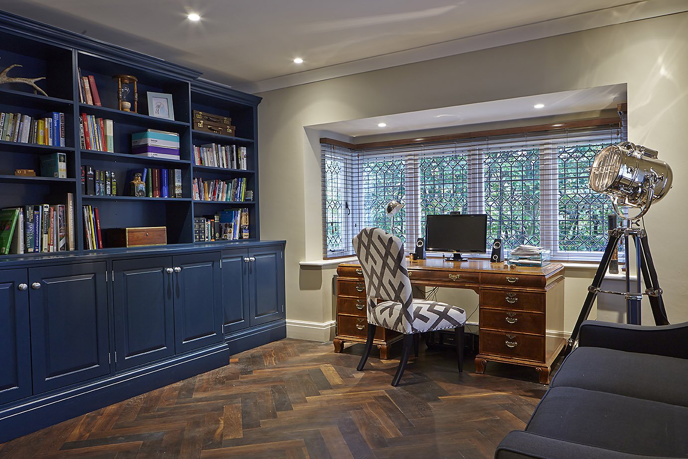 study room with blue bookshelf, wooden furniture, and herringbone floor