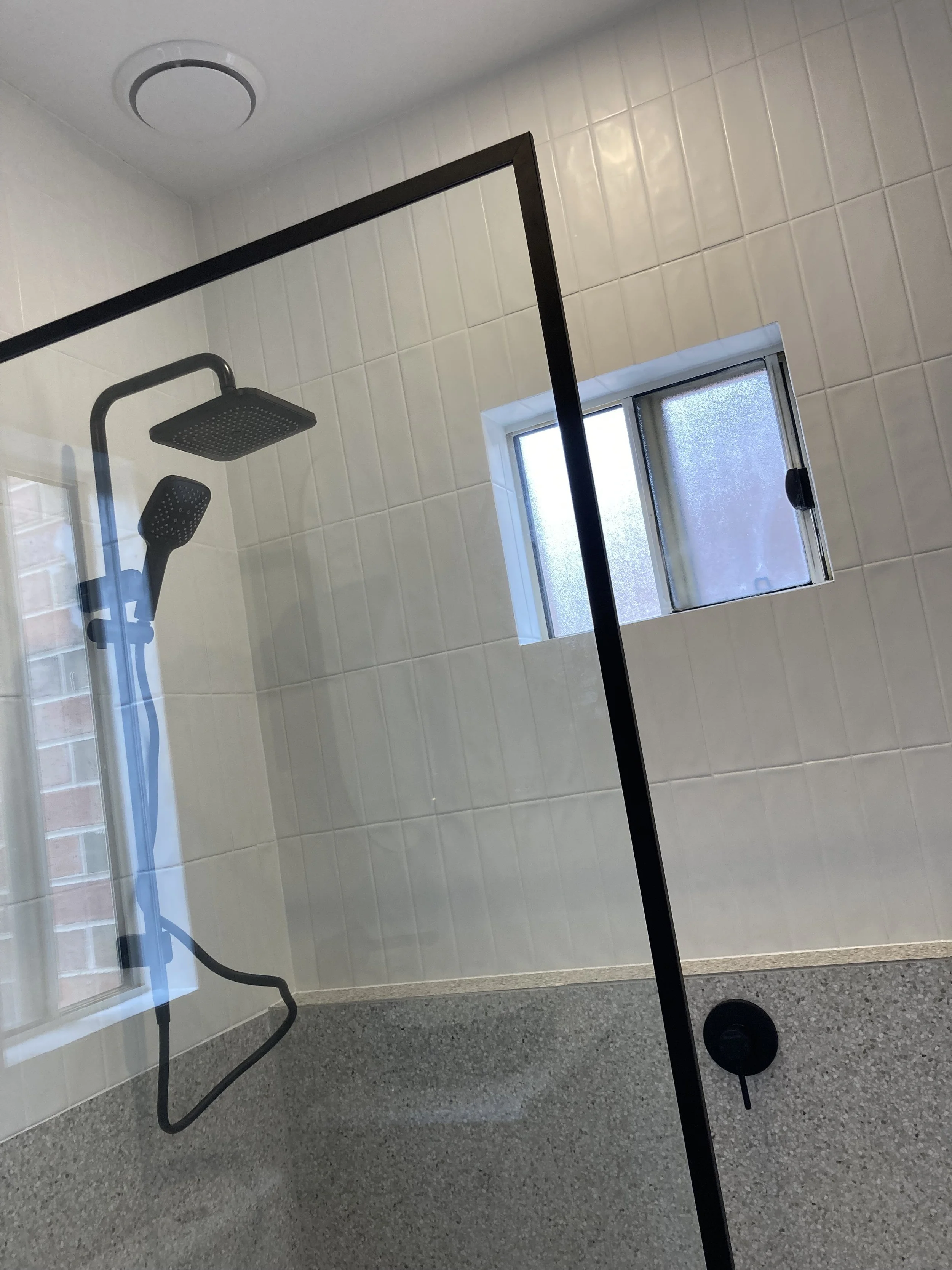 The shower with black fixtures and open design.