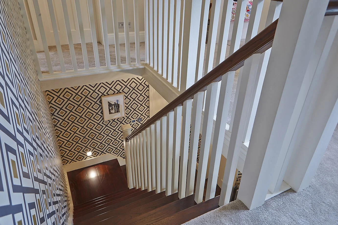 looking down from the top of the staircase, showing art deco patterned wall 