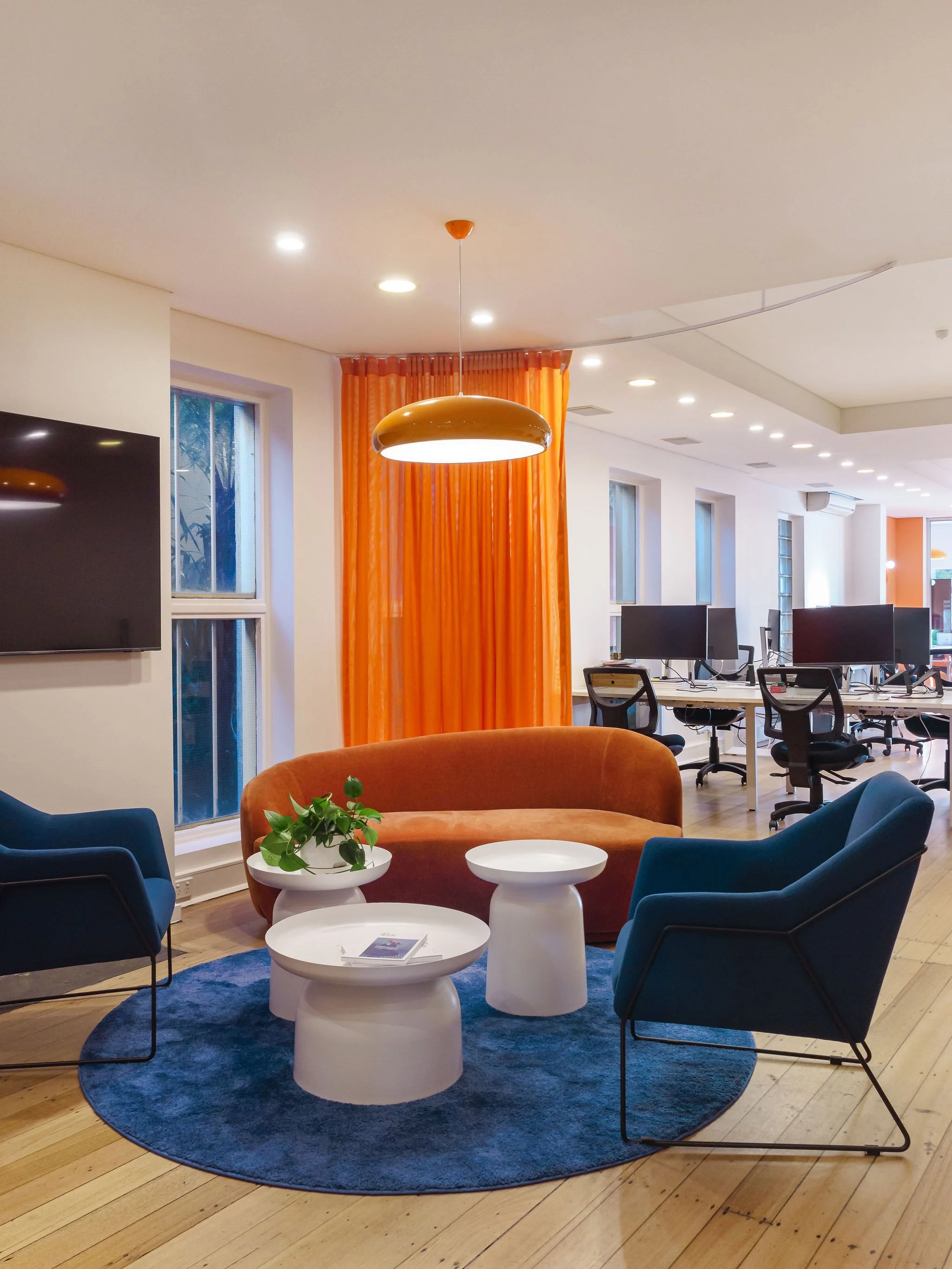 Wide view of the agency interior design. This angle shows how we balanced brand expression with functionality. Practical sitting furniture with colours to match the bran. In the back you can see modern workstations.