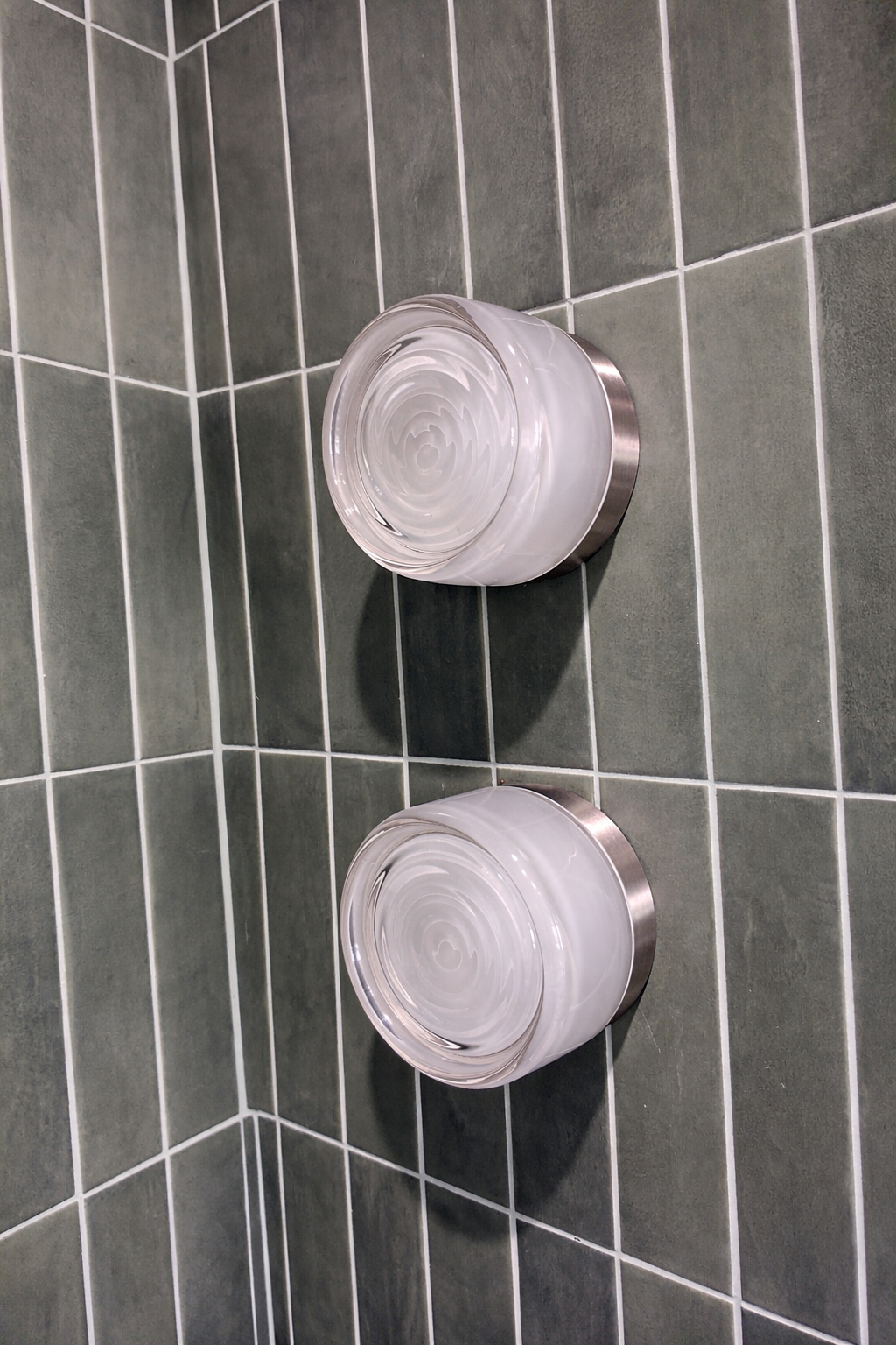 bathroom fixtures on top of green-toned tiles