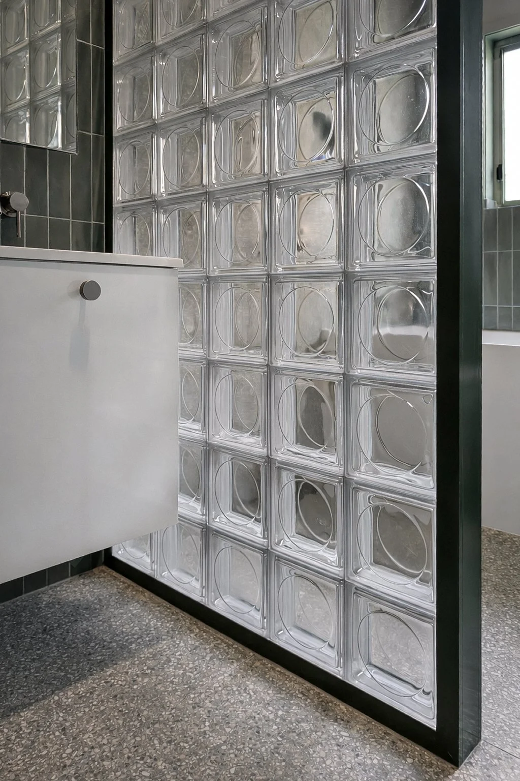 refreshed bathroom, cabinet, and glass square wall, over speckled floor 