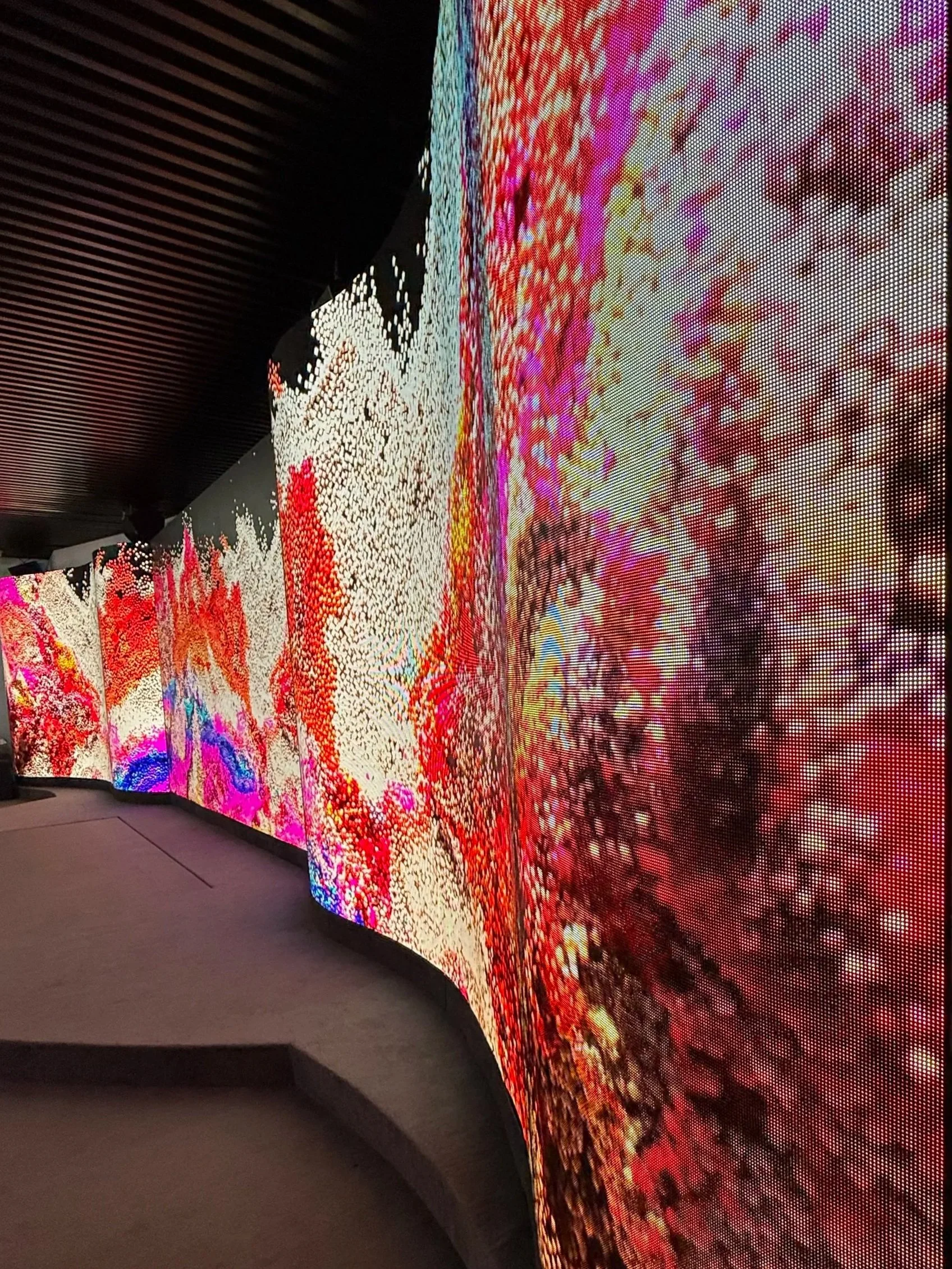 Pantalla de pantalla curva con arte digital en colores vibrantes y patrones abstractos.