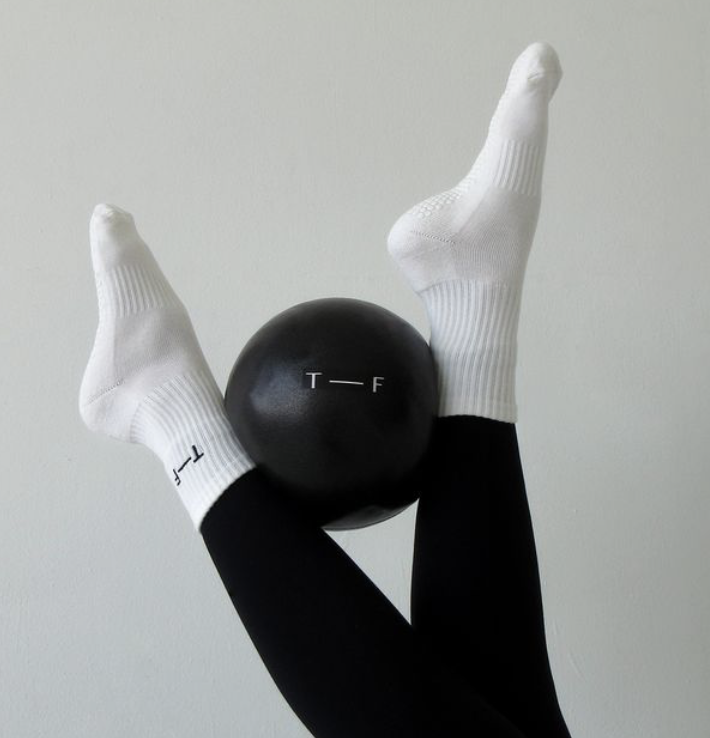 Client lifting dumbbells during low-impact Signature Strength class in London, designed to build full-body muscle tone and endurance.