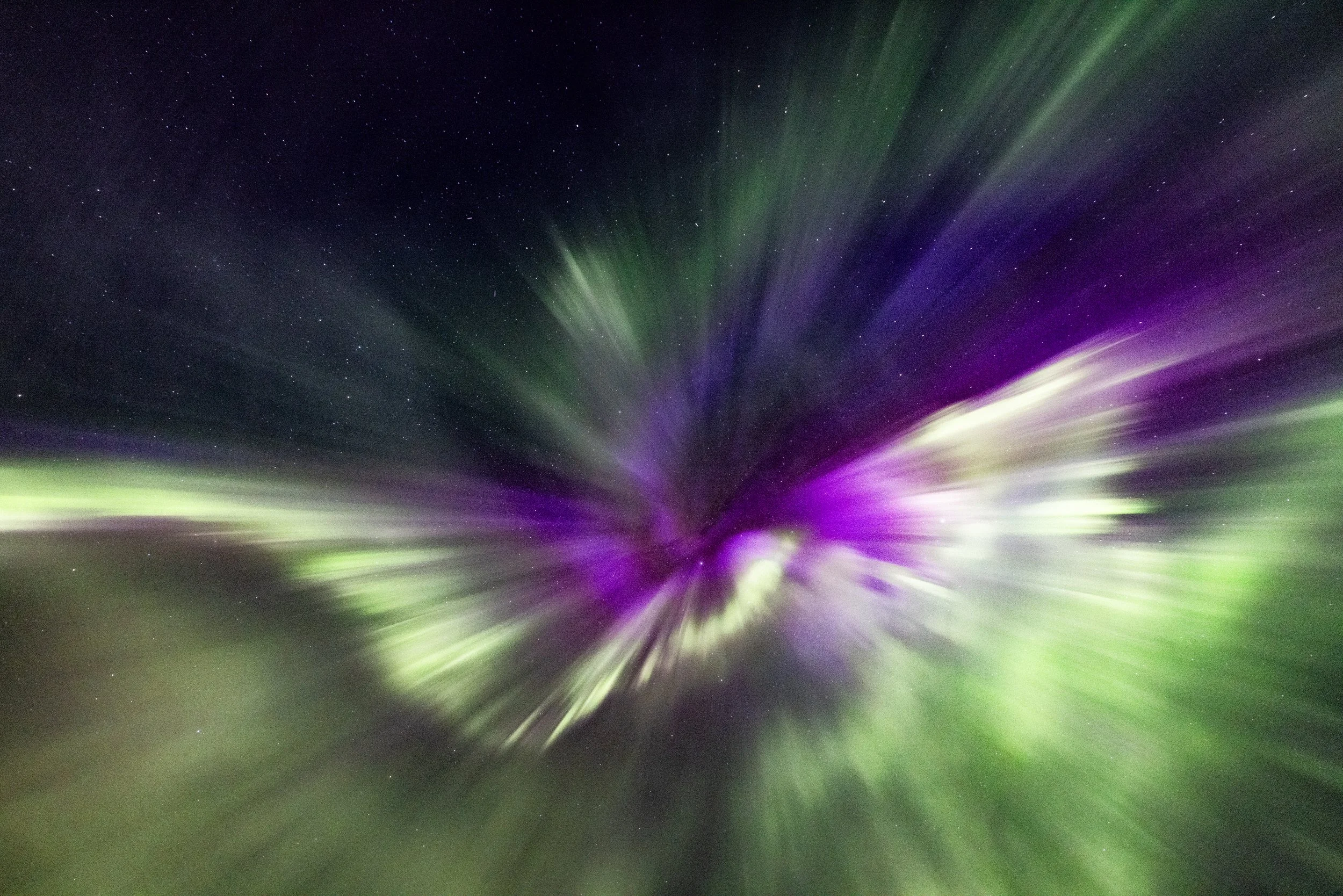 Nordlichter in Grün und Lila am Nachthimmel, Sternschnuppen sichtbar