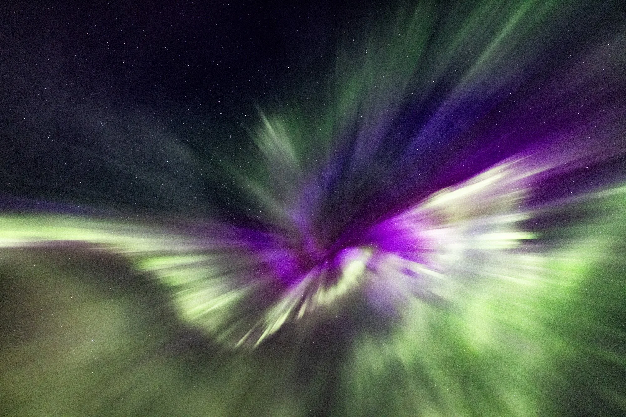 Nordlichter (Aurora Borealis) in der Nacht mit Sternenhimmel, grün und lila leuchtende Lichtstrahlen