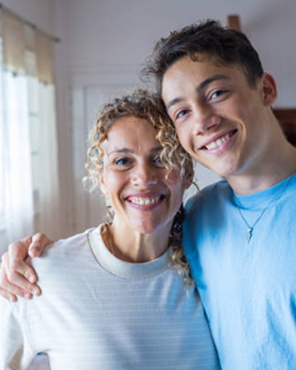 Smiling woman and teenager posing together indoors.