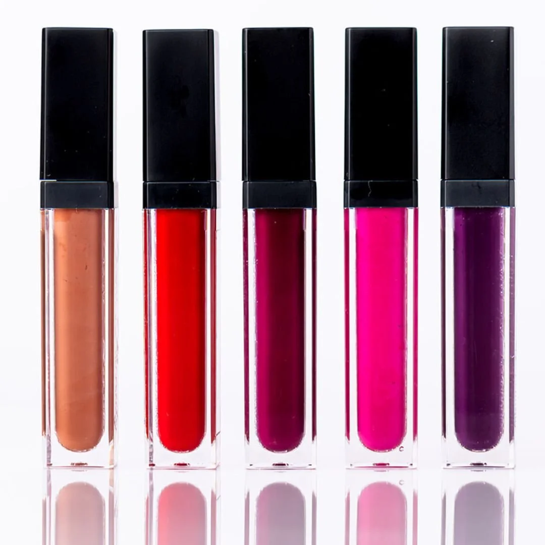 Five tubes of lipstick in shades from peach to purple, lined up against a white background.