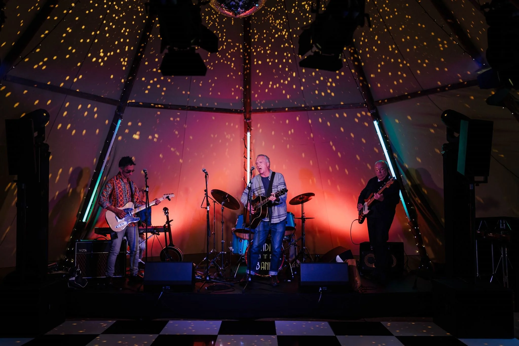 Live band performing on stage in tipi with stunning lighting