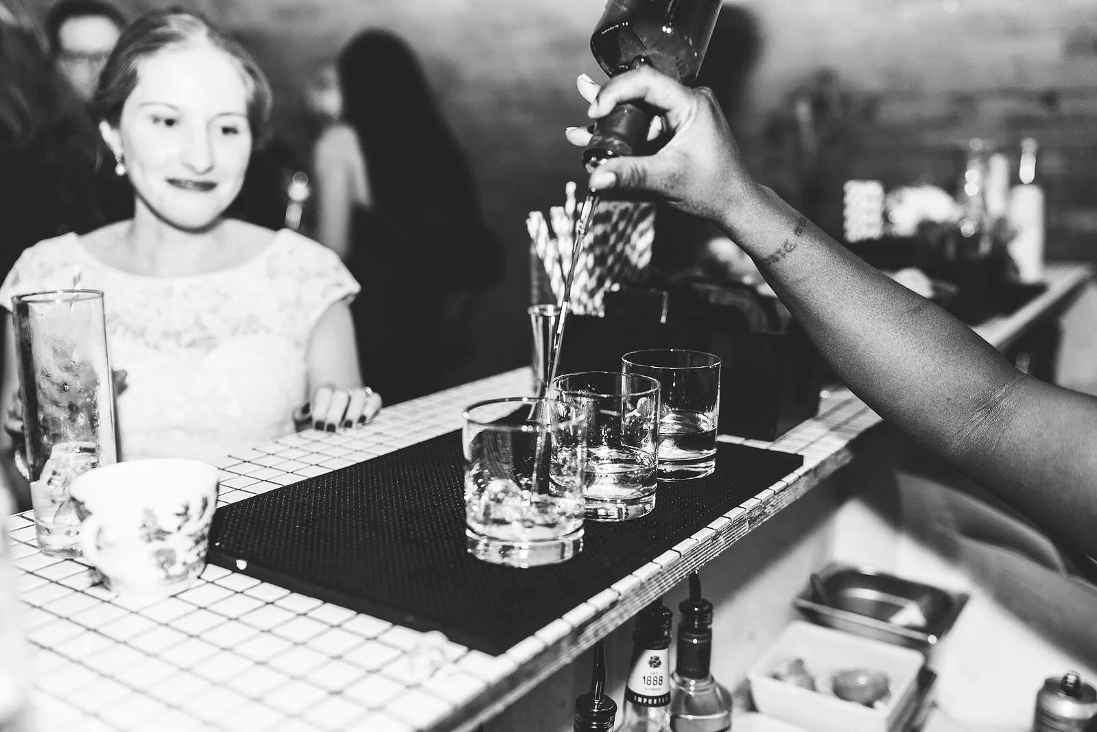 Guest at a bar whilst bar tender pours drinks at a London event