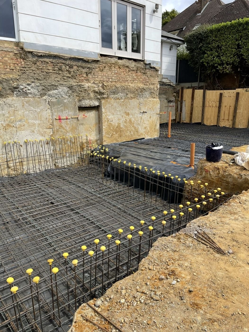 Underpinned house foundations beside retaining wall reinforcement, Matlock, Derbyshire