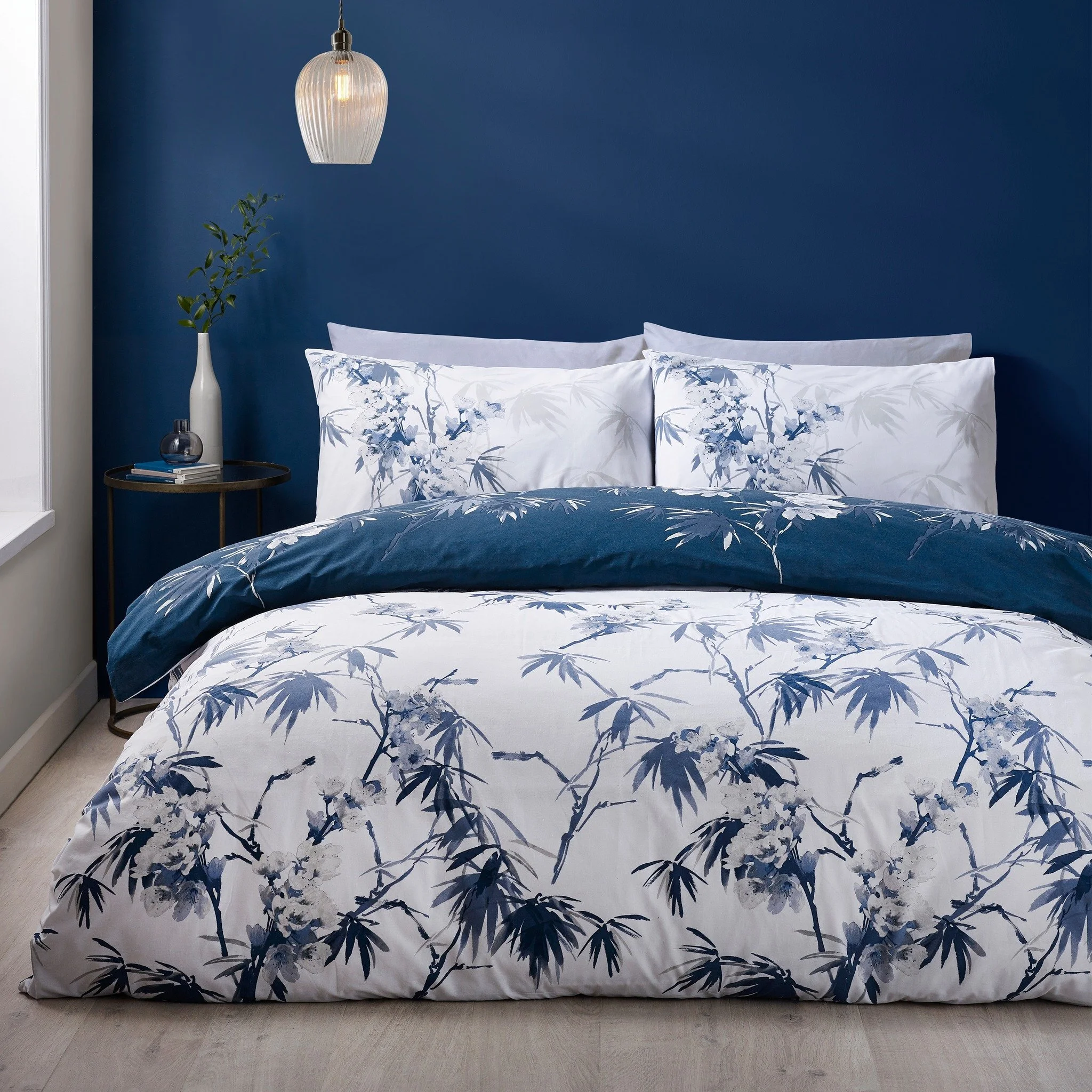 Inspired by the delicate beauty of traditional artistry, this bedding features hand-painted style blossoms and bamboo leaves in serene shades of indigo. 
A reversible design lets you switch from a fresh white canvas to a deep midnight backdrop for ve