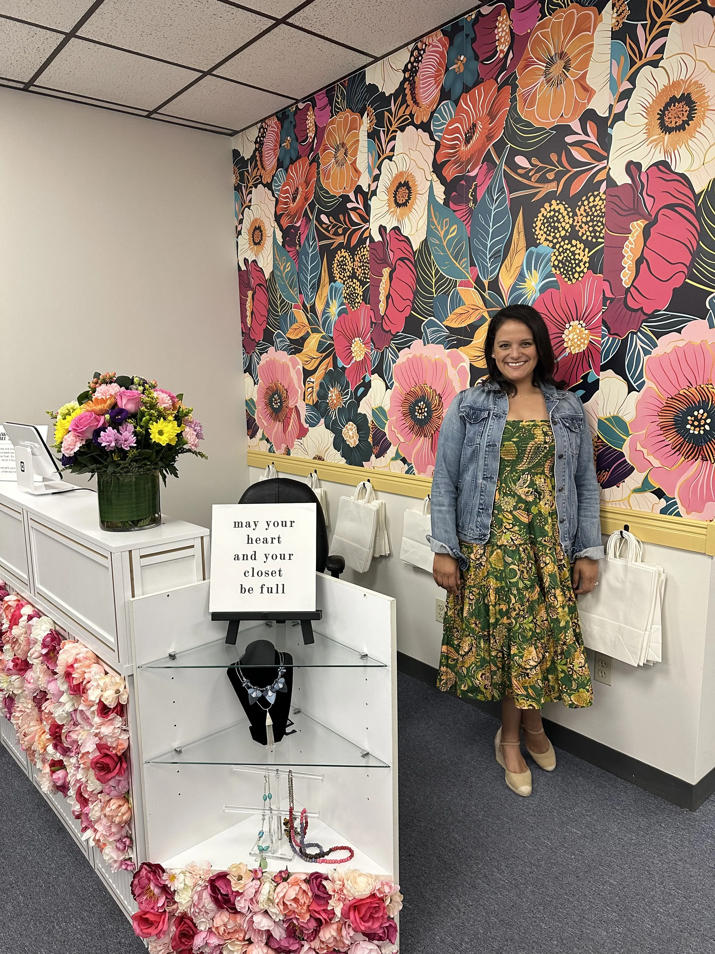 Owner, Cassandra Falone, at checkout counter of re/CHIC Waltham Curated thrift store
