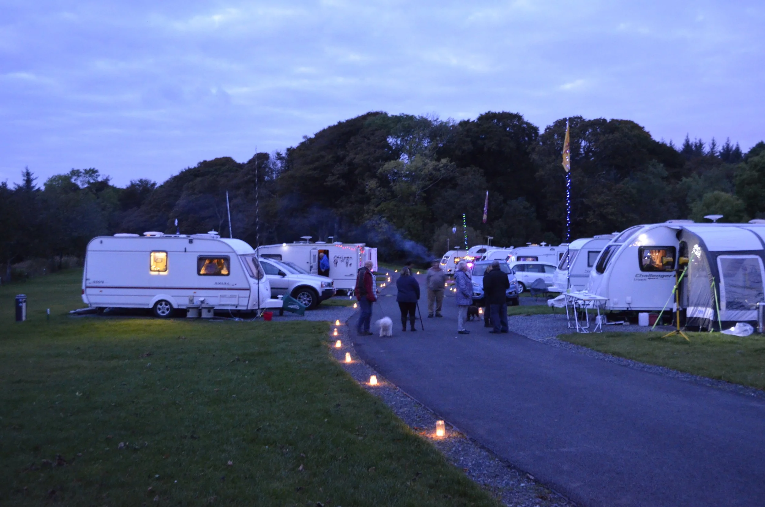 caravan site with lanterns at roadside at dusk